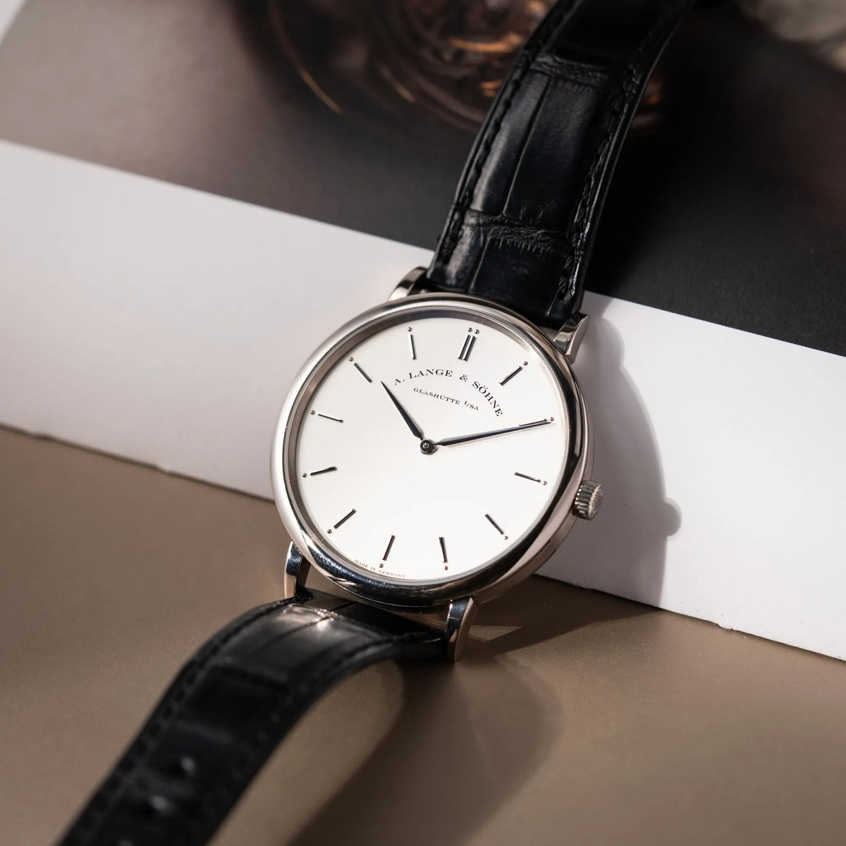 Produktfotografie der A.Lange Söhne Saxonia Thin der Referenz 211.026 im Weißgold-Gehäuse mit weiß-silbernem Zifferblatt am schwarzen Lederarmband
