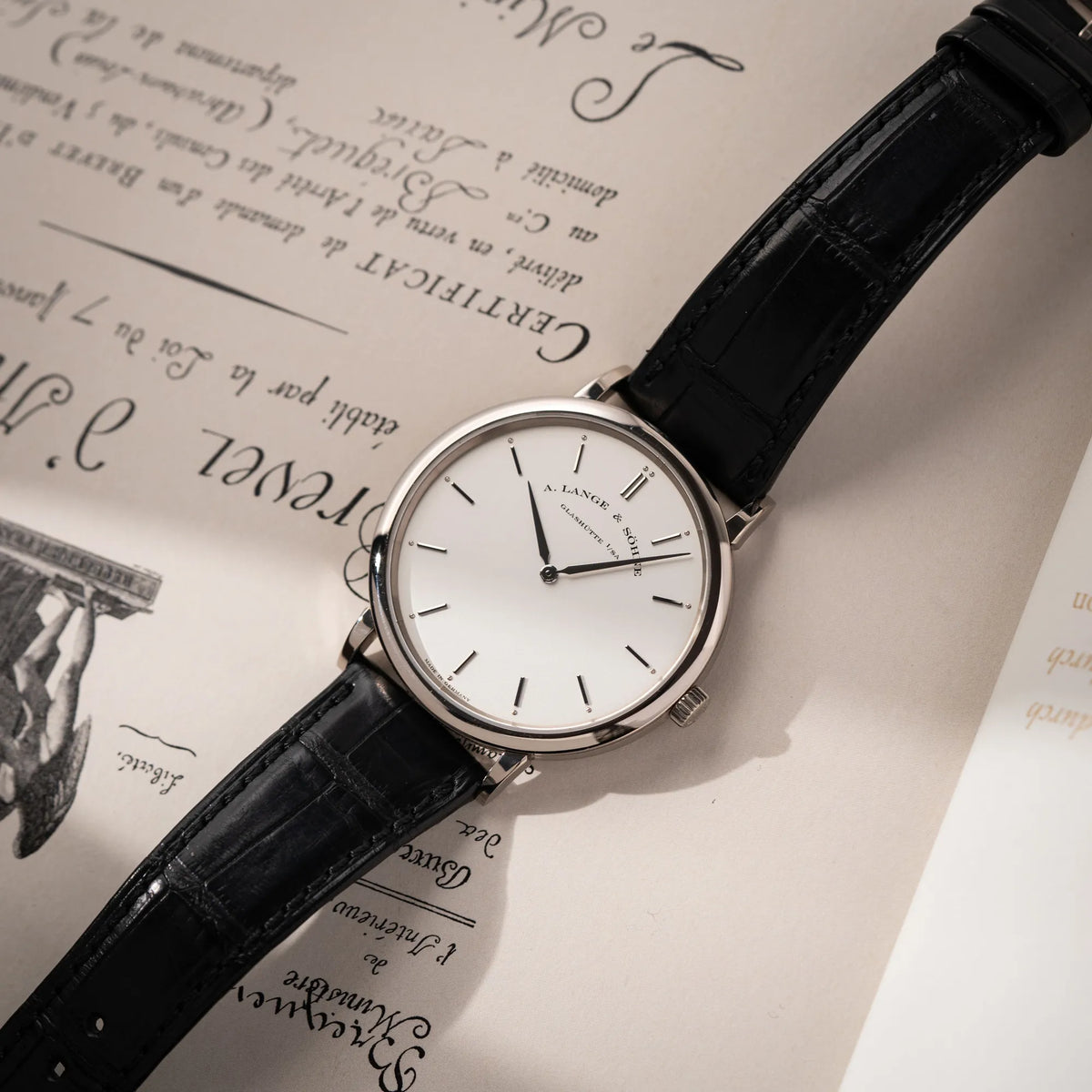 A.Lange Söhne Saxonia Thin der Referenz 211.026 im Weißgold-Gehäuse mit weiß-silbernem Zifferblatt am schwarzen Lederarmband