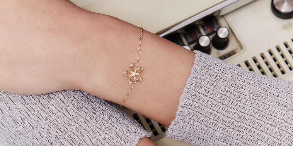 Frau trägt ein Alisia Schmuck-Armbändchen mit Blumendetail an Ihrem Handgelenk 