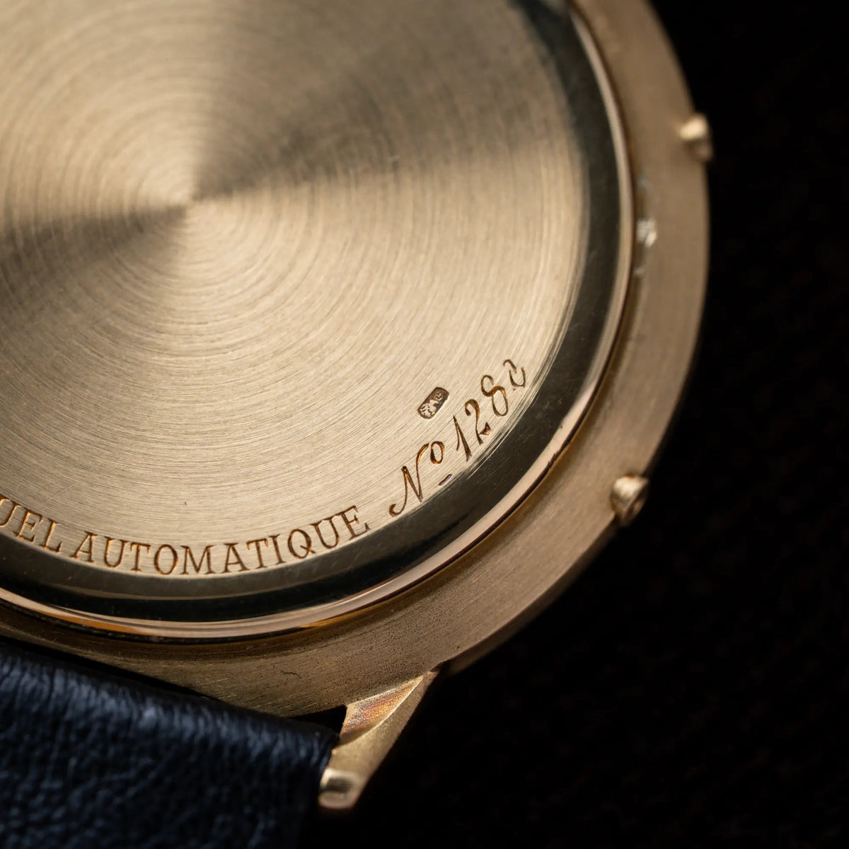 Gehäuseboden der Audemars Piguet Quantième Perpétual der Referenz 5548BA mit 36mm-Gelbgold-Gehäuse und weißem Zifferblatt an einem schwarzen Lederband