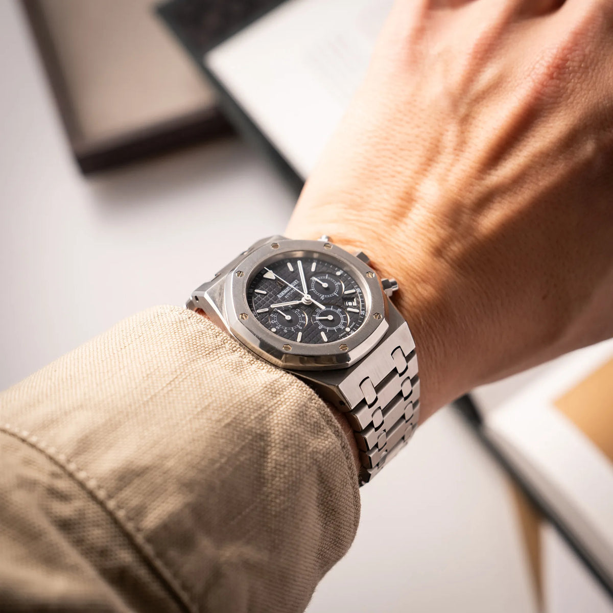 Mann präsentiert die Audemars Piguet Royal Oak Chronograph Kasparov der Referenz 25860ST.mit blauem Tapisserie-Zifferblatt im 39mm-Edelstahl-Gehäuse an seinem Handgelenk in die Kamera, wobei die Lünette sehr gut erkennbar ist