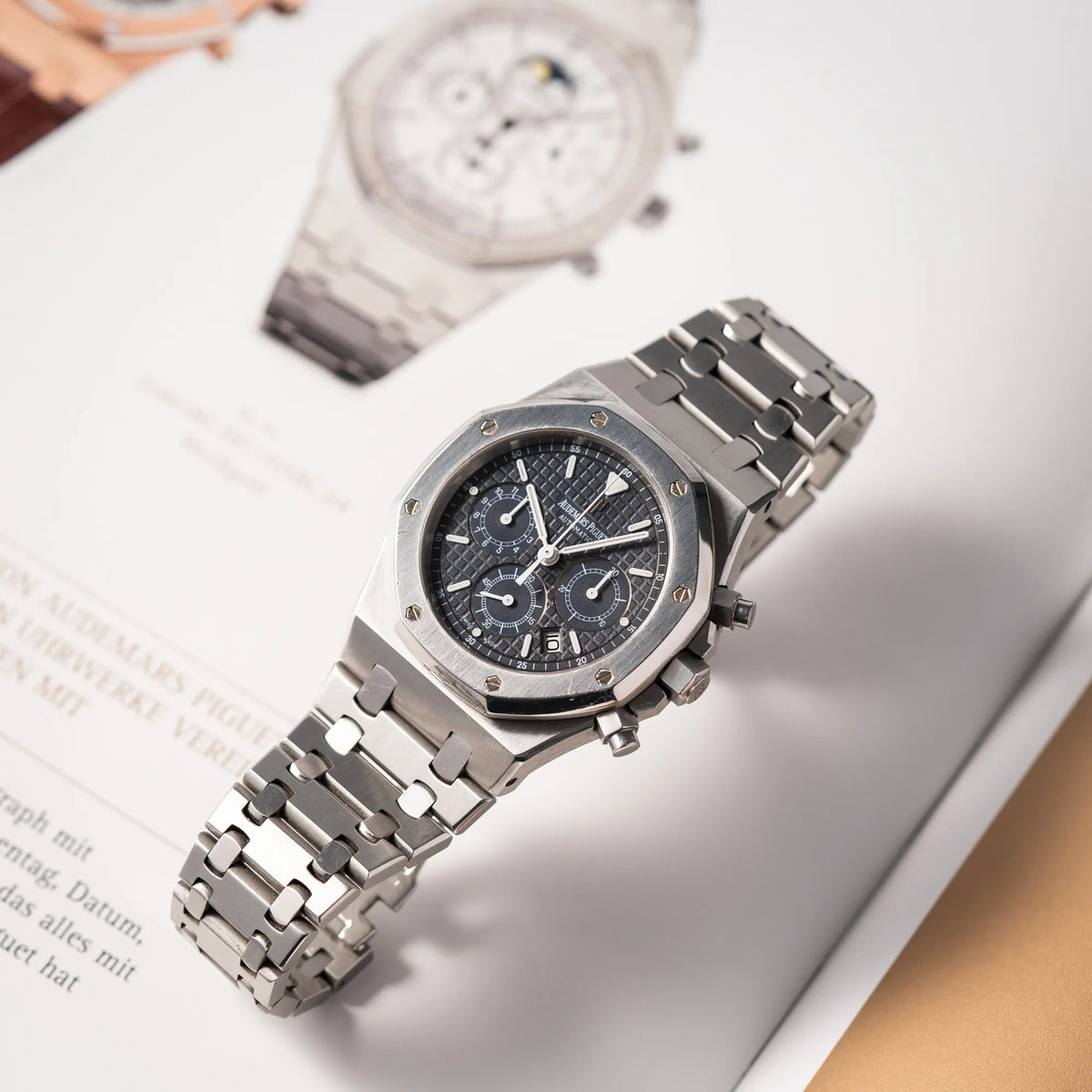 Produktfotografie der Audemars Piguet Royal Oak Chronograph Kasparov der Referenz 25860ST.mit blauem Tapisserie-Zifferblatt im 39mm-Edelstahl-Gehäuse, während die Uhr auf dem Uhrenband steht