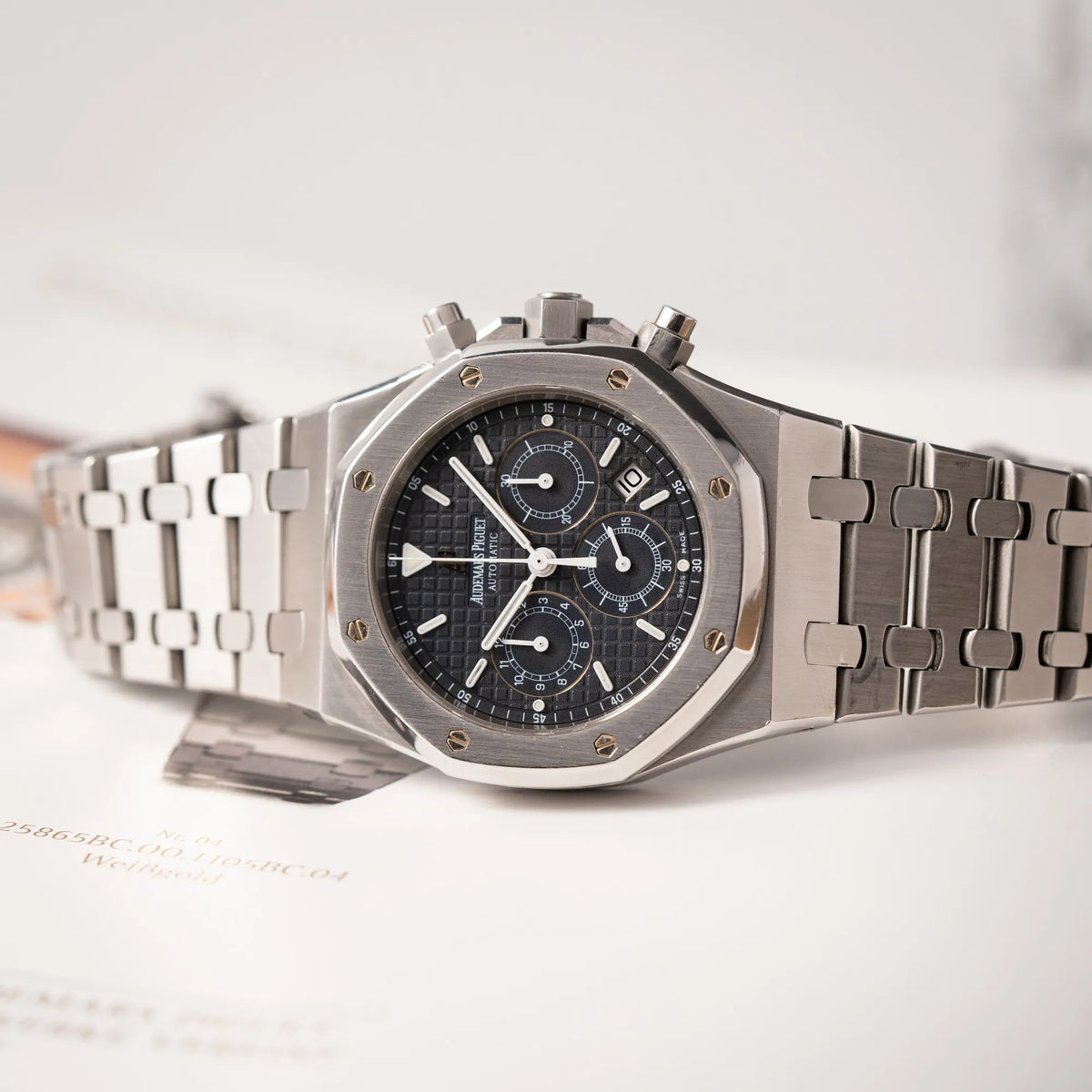 Detailaufnahme der seitlich auf dem Uhrengehuse liegenden Audemars Piguet Royal Oak Chronograph Kasparov der Referenz 25860ST.mit blauem Tapisserie-Zifferblatt im 39mm-Edelstahl-Gehäuse