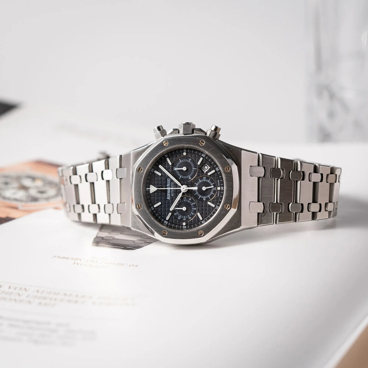 Audemars Piguet Royal Oak Chronograph Kasparov der Referenz 25860ST.mit blauem Tapisserie-Zifferblatt im 39mm-Edelstahl-Gehäuse liegt auf der seitlichen Gehäusflanke