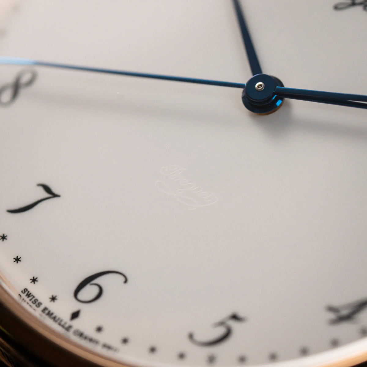 Makroaufnahme des Zifferblatts der Breguet Classique 5177 in Roségold mit weißem Emaille-Zifferblatt