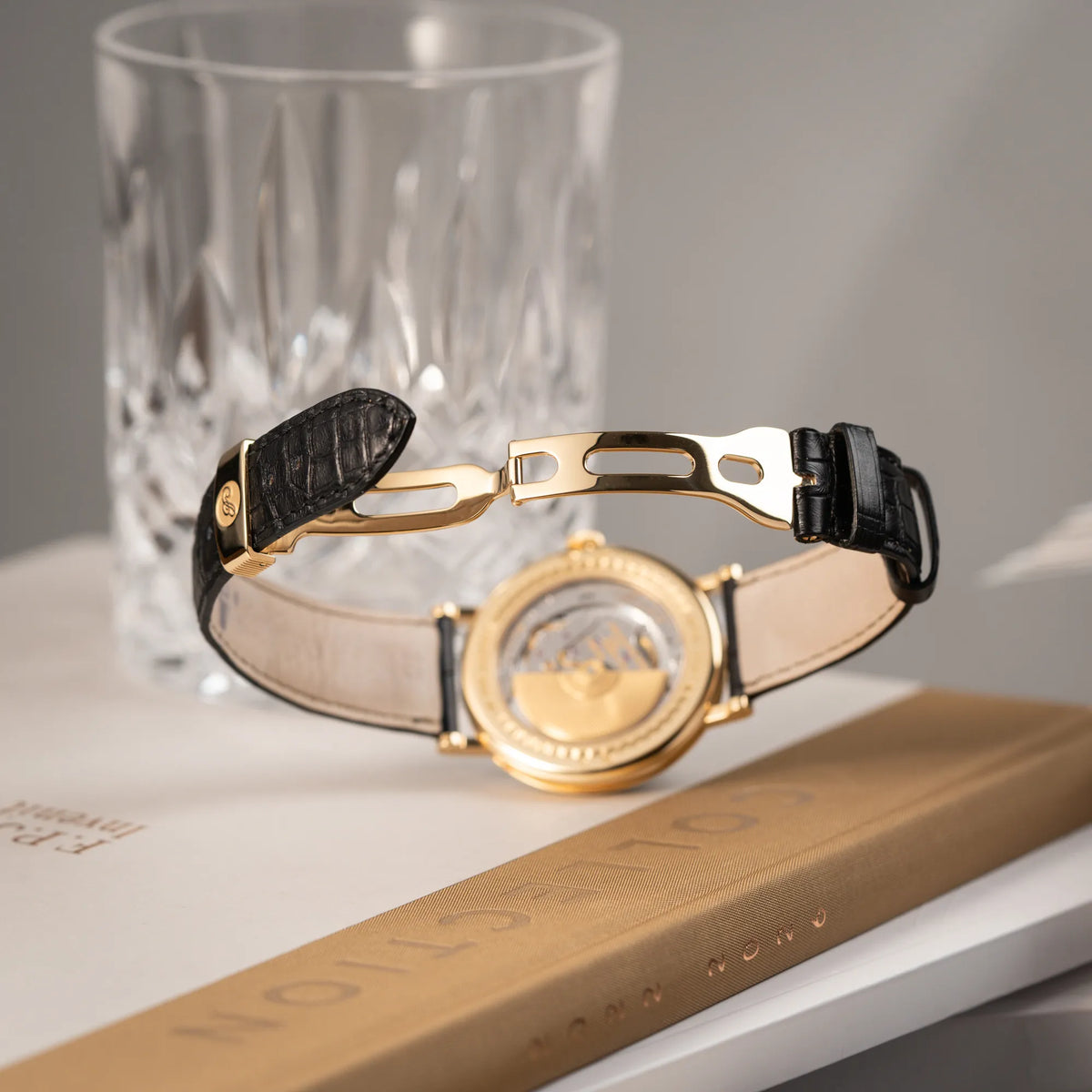Produktfotografie der Breguet Classique 7137BA mit einem Gelbgoldgehäuse in klassischer Form mit einem silbernen Zifferblatt mit jeweils einem anderen handgefertigten Guilloche-Muster für jede Komplikation  zeigt den fast neuwertigen Zustand der originalen Faltschliesse
