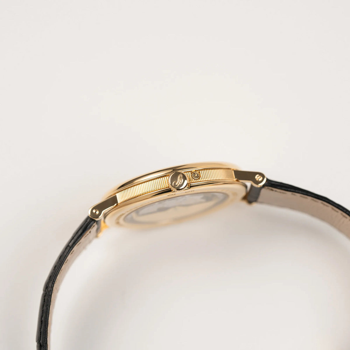 Seitliche Gehäuseflanke mit Kannellierung von der Breguet Classique 7137BA mit einem Gelbgoldgehäuse in klassischer Form mit einem silbernen Zifferblatt mit jeweils einem anderen handgefertigten Guilloche-Muster für jede Komplikation  zeigt die Aufzugskrone