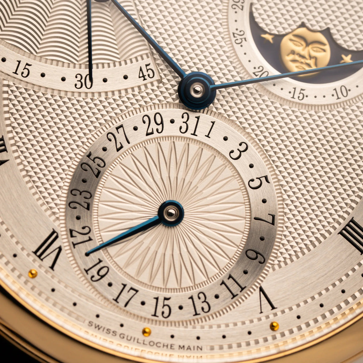 Detailaufnahme der Breguet Classique Mondphase 7137 in Gelbgold mit silbernen, verschieden guillochiertem Zifferblatt mit Fokus auf der Datumsazeige mit Blumen-Guilloche