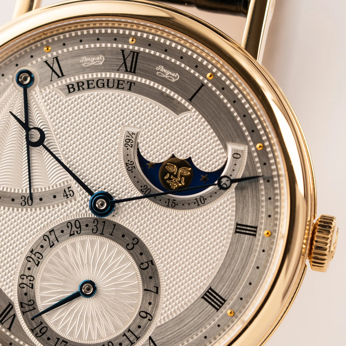 Detailaufnahme der  Breguet Classique Mondphase 7137 in Gelbgold mit silbernen, verschieden guillochiertem Zifferblatt mit Fokus auf der Mondphasenanzeige