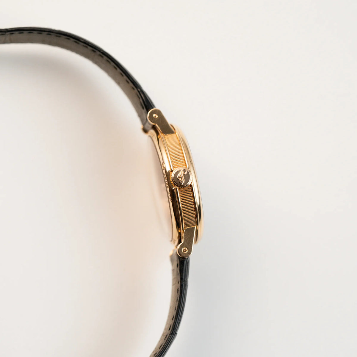 Seitliches Gehäuse der klassischen Breguet Tradition  Armbanduhr mit Rosegold-Gehäuse und schwarzem Zifferblatt mit Blick auf die Aufzugskrone