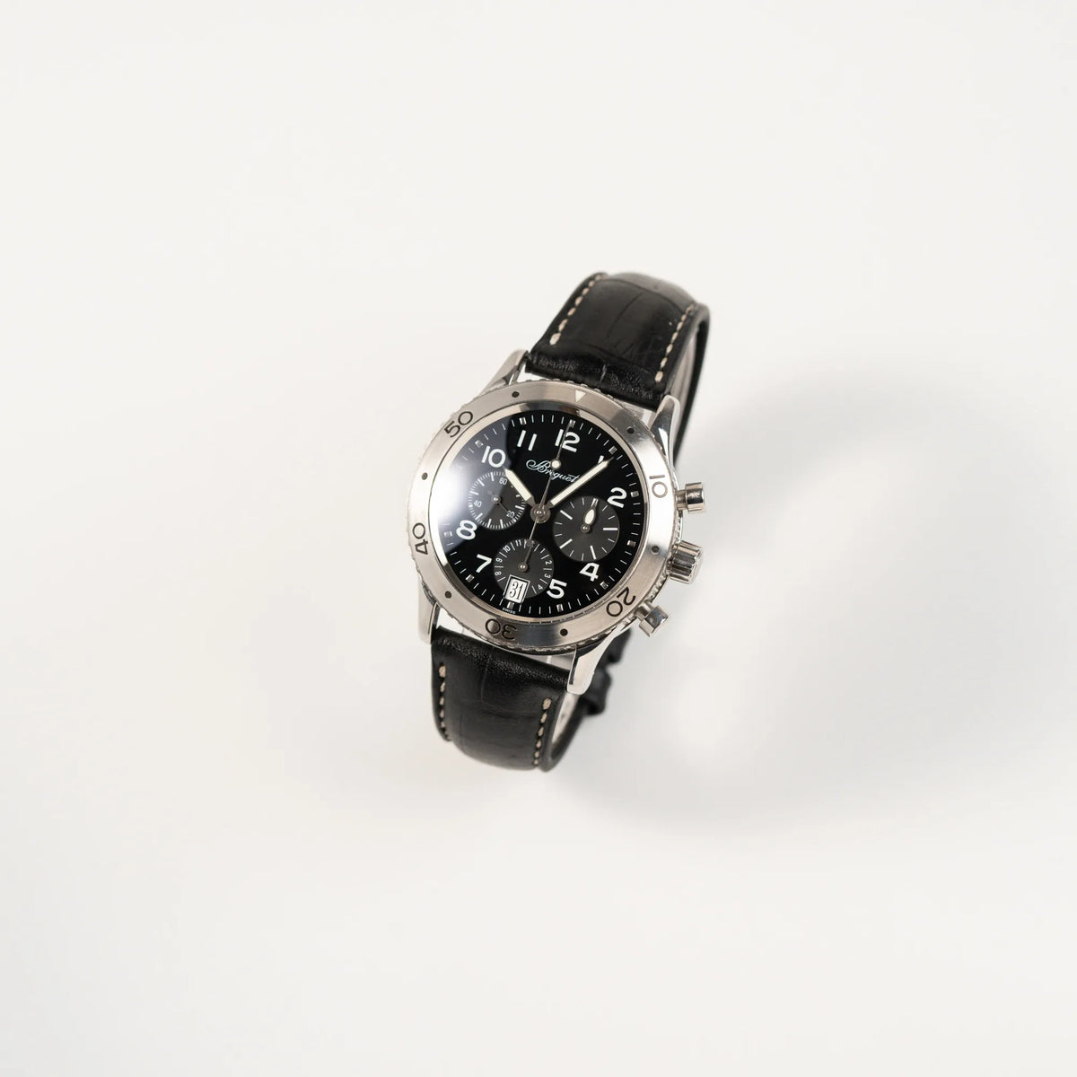 Leicht schräge Ansicht der Breguet Type XX Aéronavale Transatlantique der Referenz 3820ST mit schwarzem Lack-Zifferblatt am originalen schwarzen Breguet-Lederband