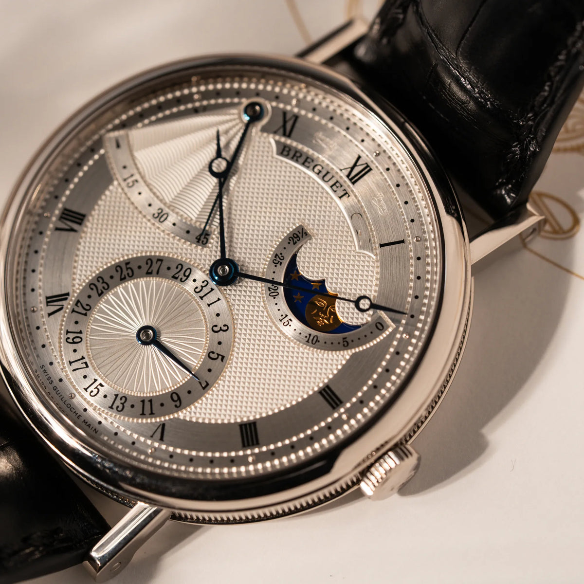 Detailaufnahme der Breguet Classique Moonphase der Referenz 7137 in Weissgold mit 3-fach guillochiertem Zifferblatt und Mondphase-Anzeige zeigt die drei verschiedenen Guilloche-Muster