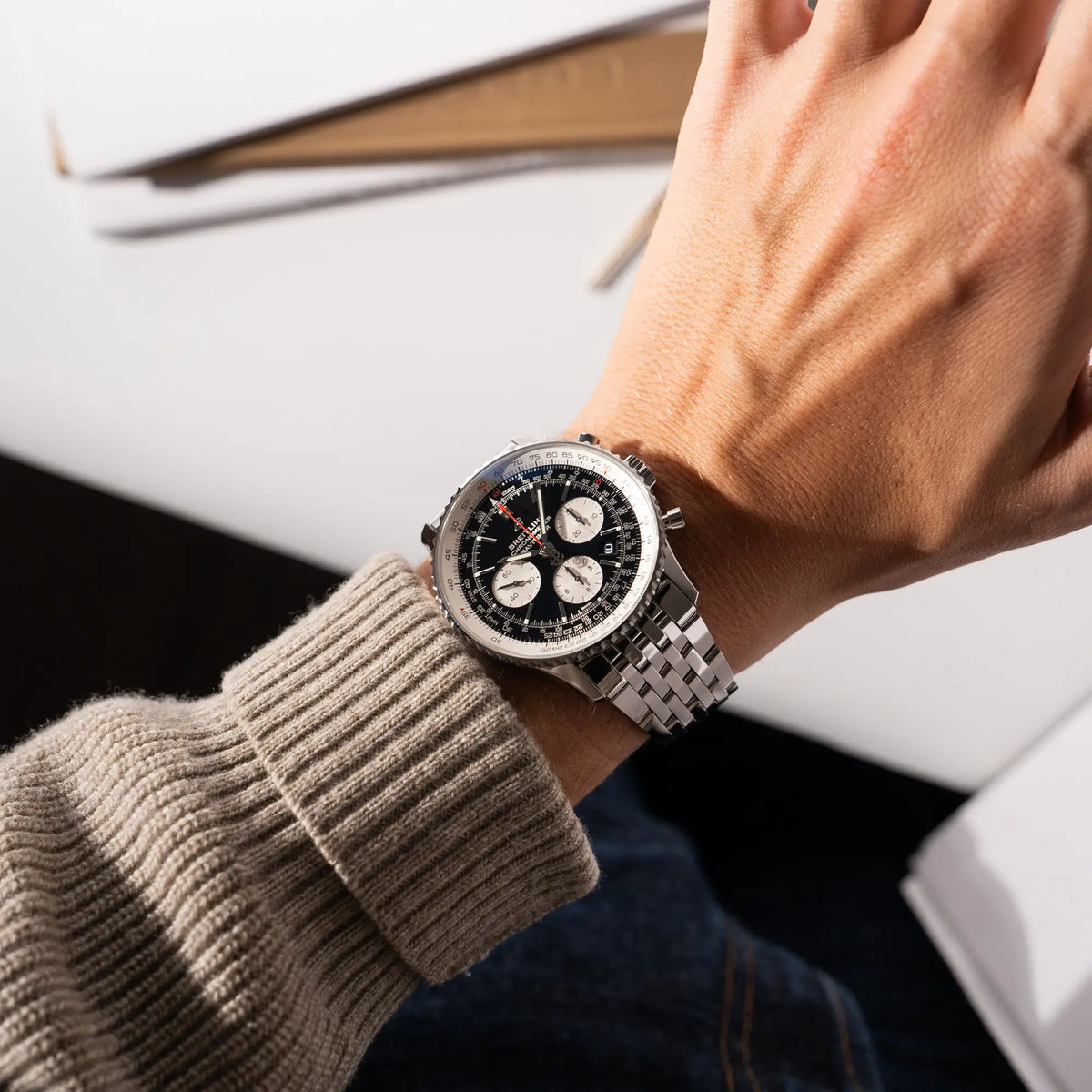 Mann präsentiert die Breitling Navitimer B01 Chronograph der Referenz AB0121211B1A1 mit Reverse-Panda Zifferblatt in schwarz mit weißen Hilfszifferblätter an seinem Handgelenk