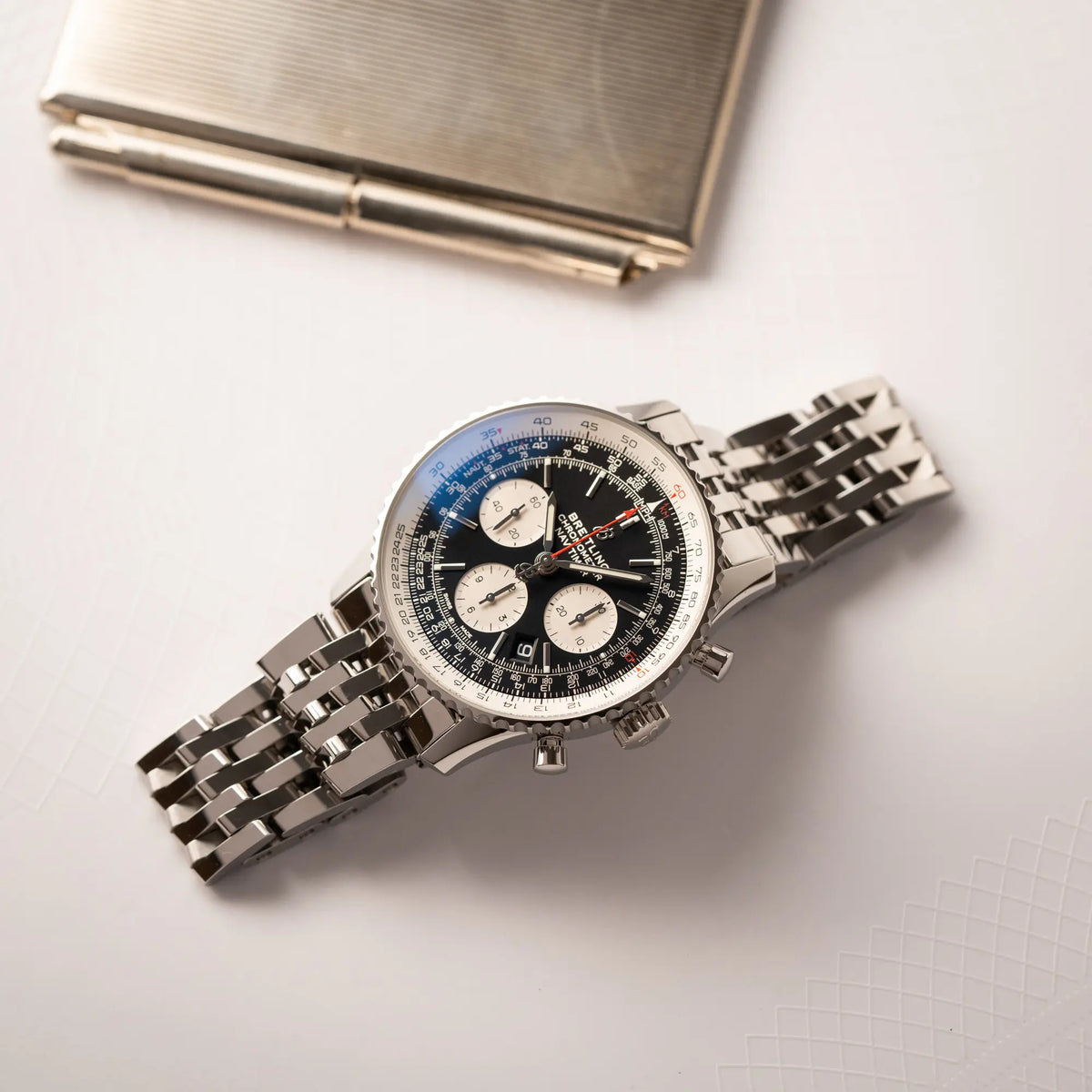 Breitling Navitimer B01 Chronograph der Referenz AB0121211B1A1 mit Reverse-Panda Zifferblatt in schwarz mit weißen Hilfszifferblätter liegt flach auf einem Tisch