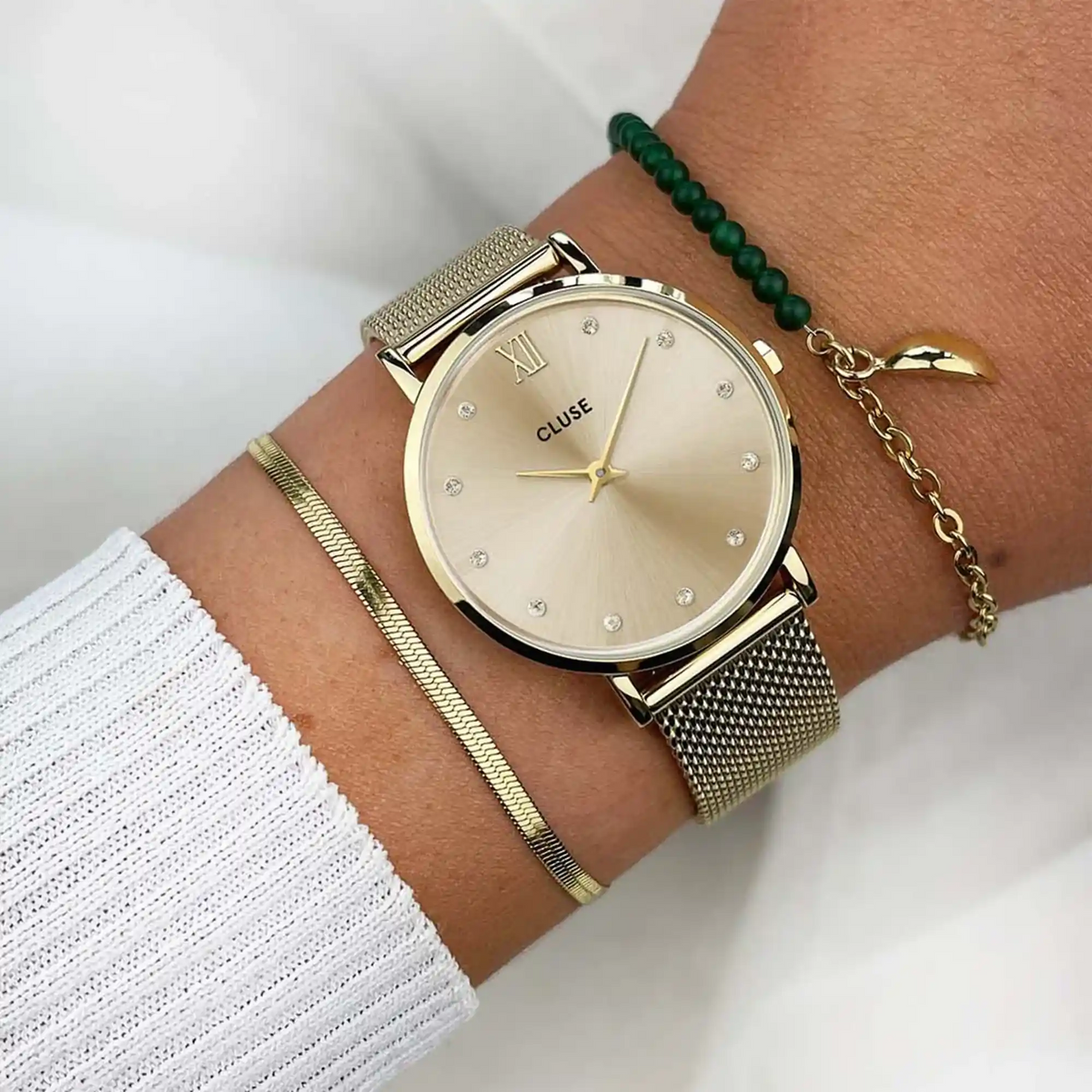 Wristshot mit der goldfarbenen Cluse Damenuhr Minuit CW10204 mit rundem Gehäuse, einem goldfarbenem Zifferblatt mit Zirkonia-Steinen als Indizes und einem feinem Mesh-Uhrenarmband