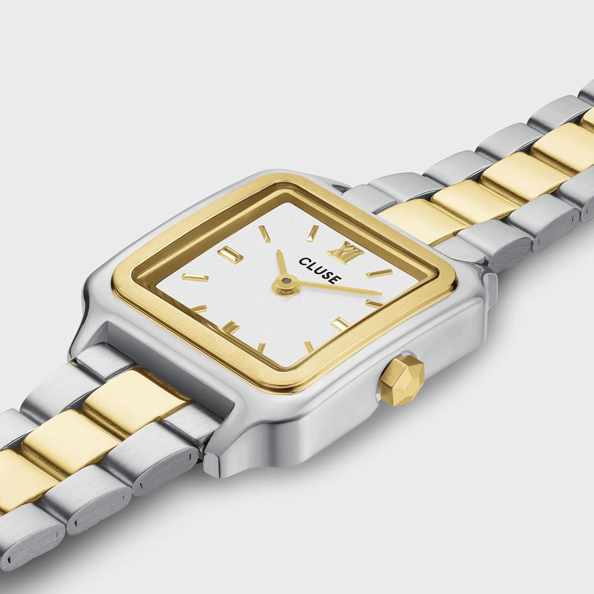 Leicht seitliche Detailansicht der stahl-goldfarbenen Cluse Damenuhr Gracieuse Mini CW15501 mit quadratischen Gehäuse, einem weißem Zifferblatt und einem passenden stahl-goldfarbenen Uhrenarmband 