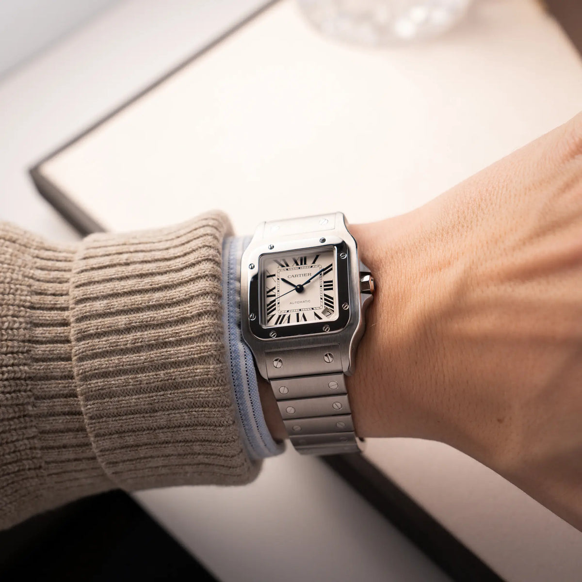 Mann trägt die Cartier Santos Galbée 2823 in Edelstahl mit weißem Zifferblatt für eine Wristhot an seinem Handgelenk