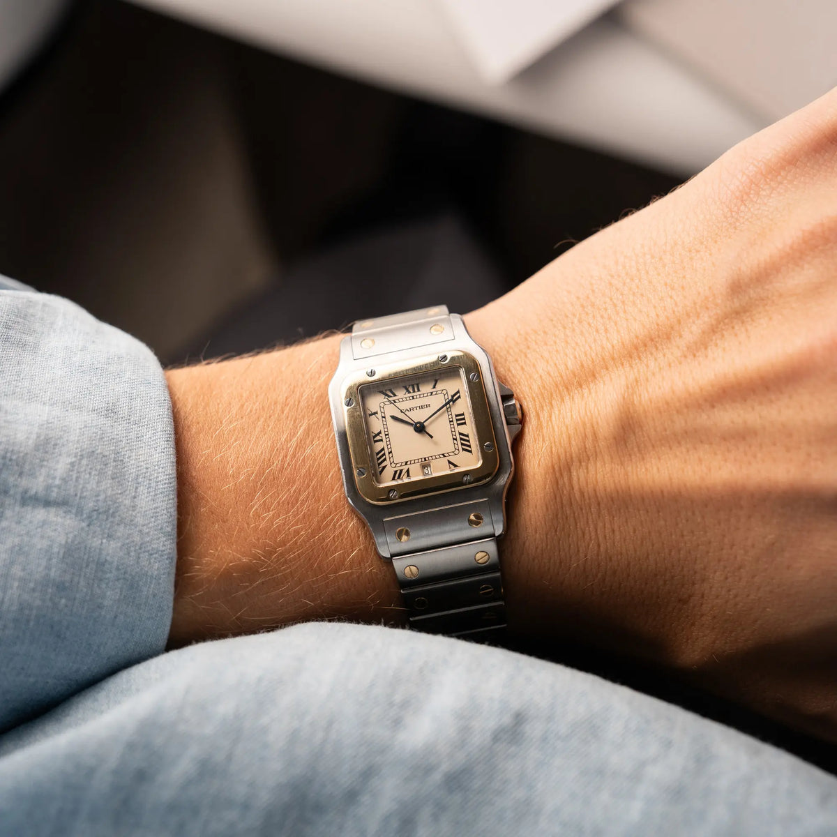 Wristshot mit der Cartier Santos Galbee BiColor der Referenz 187901 mit Stahl-Gold-Gehäuse am Stahlband  mit dem Cartier-typischen Schrauben, die ebenfalls in Gelbgold gehalten sind, und einem cremfarbenen Zifferblatt mit klassischen römischen Indizes
