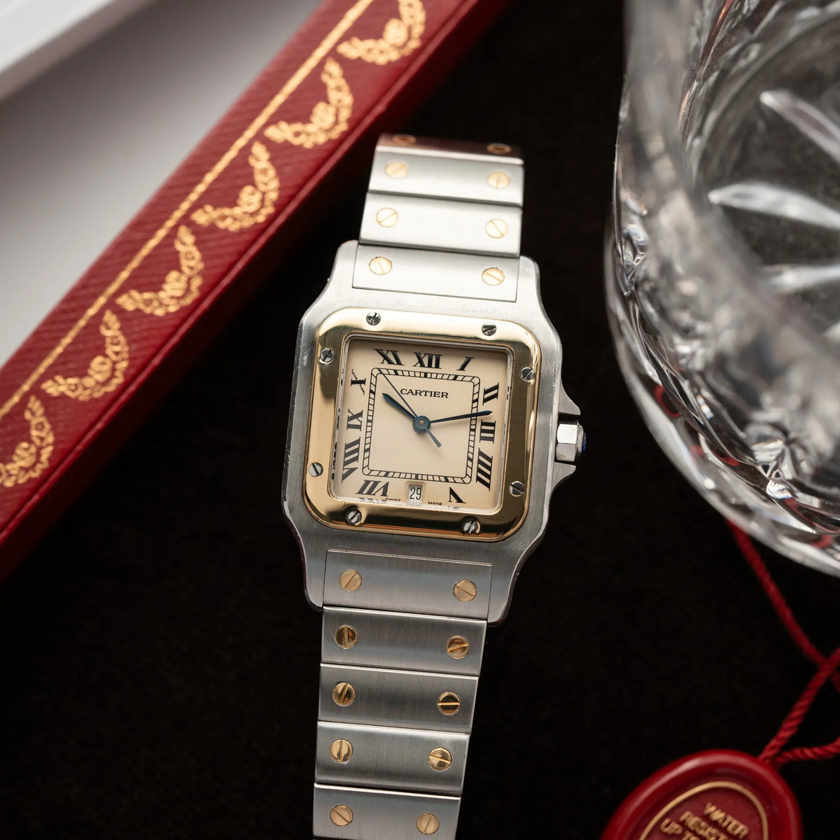 Produktofografie der Cartier Santos Galbee BiColor der Referenz 187901 mit Stahl-Gold-Gehäuse am Stahlband  mit dem Cartier-typischen Schrauben, die ebenfalls in Gelbgold gehalten sind, und einem cremfarbenen Zifferblatt mit klassischen römischen Indizes