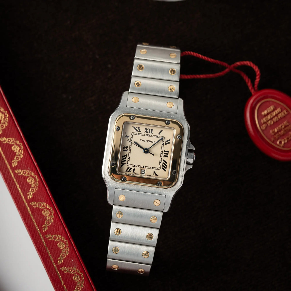 Produktfotografie der Cartier Santos Galbee BiColor der Referenz 187901 mit Stahl-Gold-Gehäuse am Stahlband  mit dem Cartier-typischen Schrauben, die ebenfalls in Gelbgold gehalten sind, und einem cremfarbenen Zifferblatt mit klassischen römischen Indizes