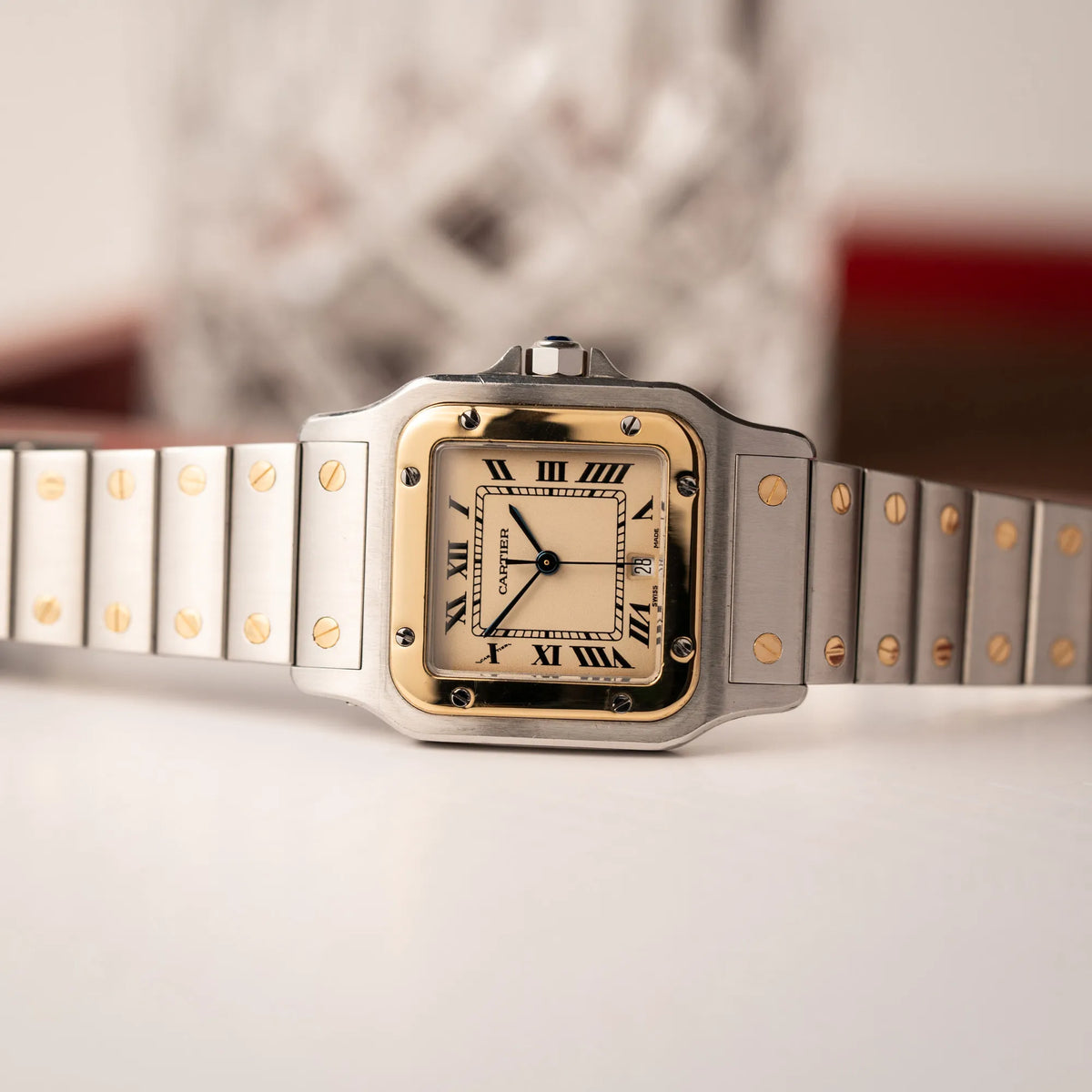 Produktfotografie als Titelbild für die Cartier Santos Galbee BiColor der Referenz 187901 mit Stahl-Gold-Gehäuse am Stahlband  mit dem Cartier-typischen Schrauben, die ebenfalls in Gelbgold gehalten sind, und einem cremfarbenen Zifferblatt mit klassischen römischen Indizes