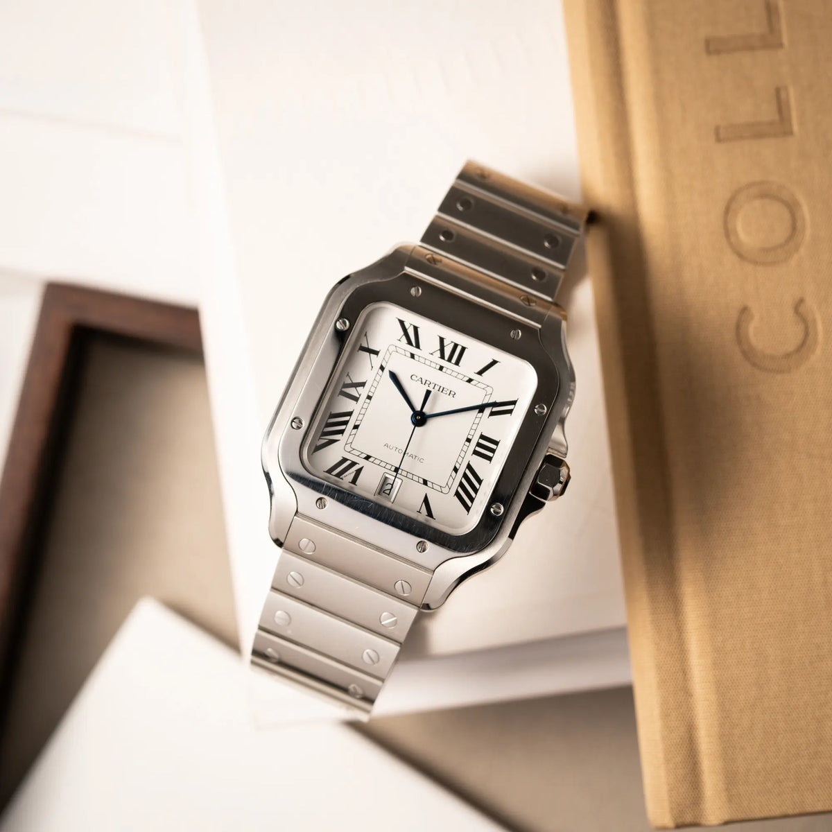 Produktfotografie als Titelbild für die Cartier Santos de Cartier als großes Modell der Referenz WSA0018 mit dem klassischen weißen Zifferblatt und römischen Indizes