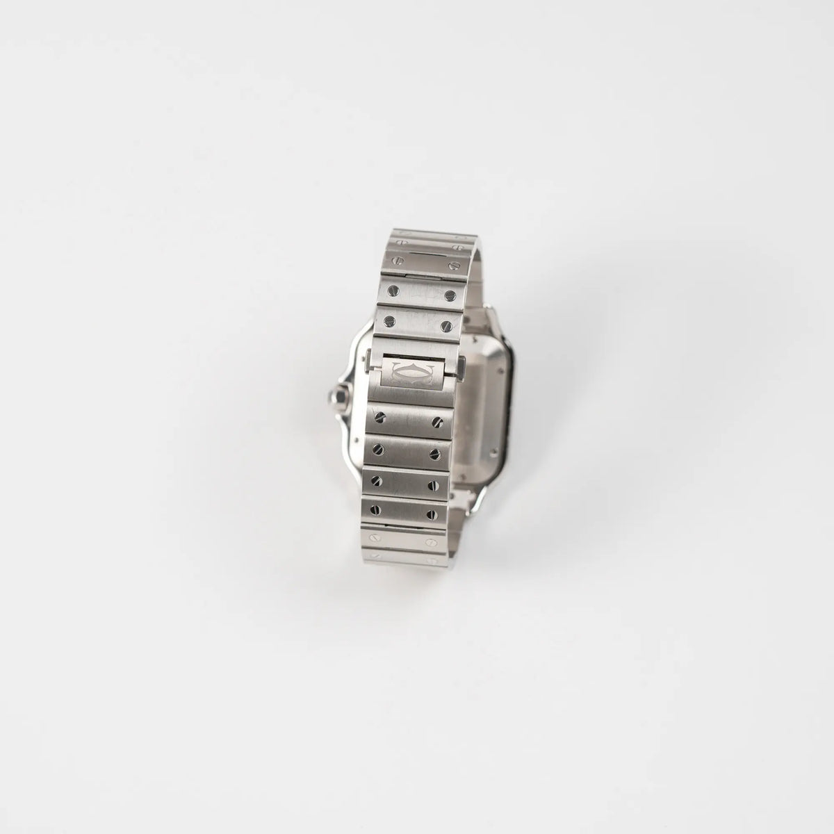 Blick auf das originale Edelstahl-Armband mit typischen Schrauben-Details von der Cartier Santos de Cartier als großes Modell der Referenz WSA0018 mit dem klassischen weißen Zifferblatt und römischen Indizes zeigt die Uhr mit den polierten und satinierten Oberflächen