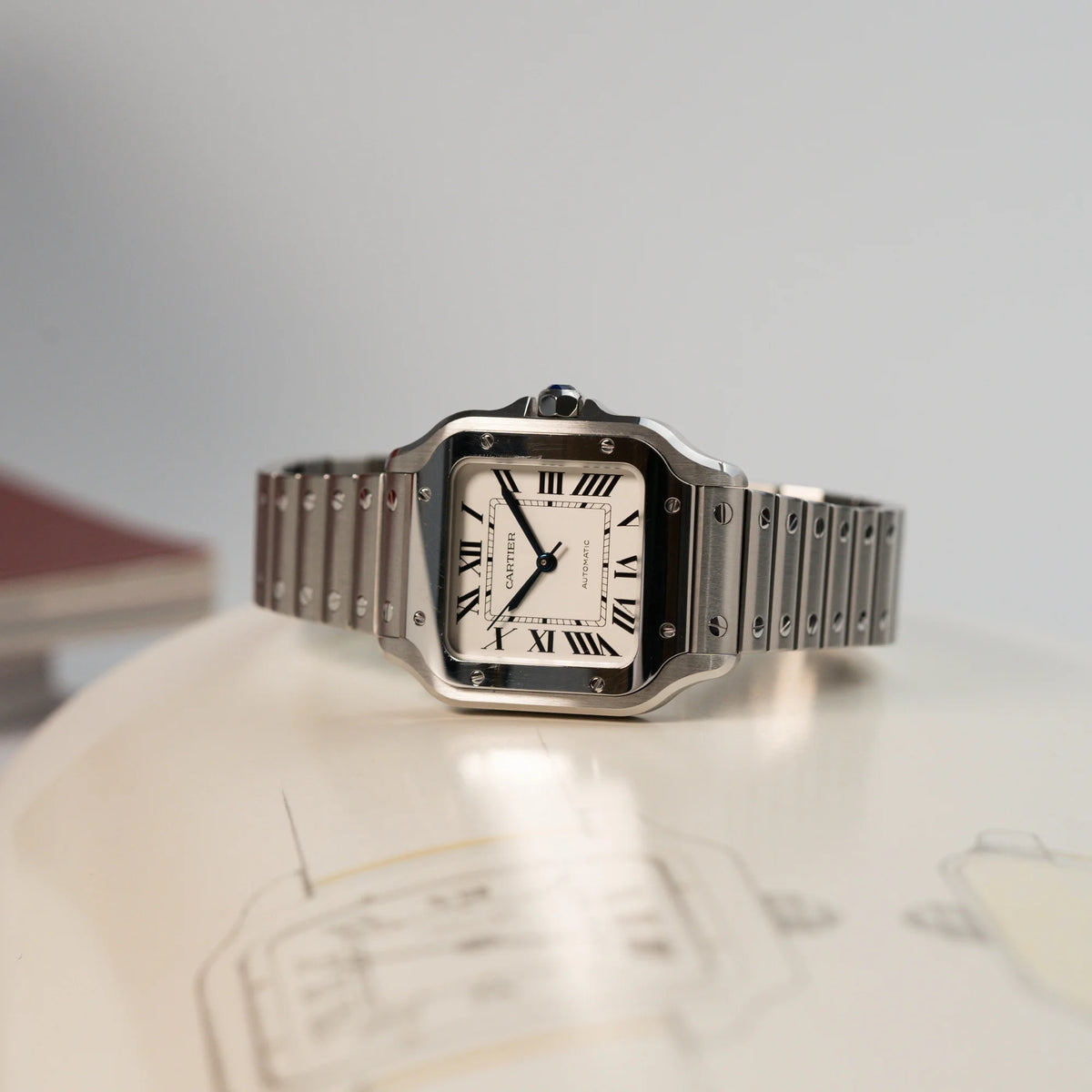 Produktfotografie der liegenden Cartier Santos Medium mit dem klassischen weißen Zifferblatt mit römischen Indizes