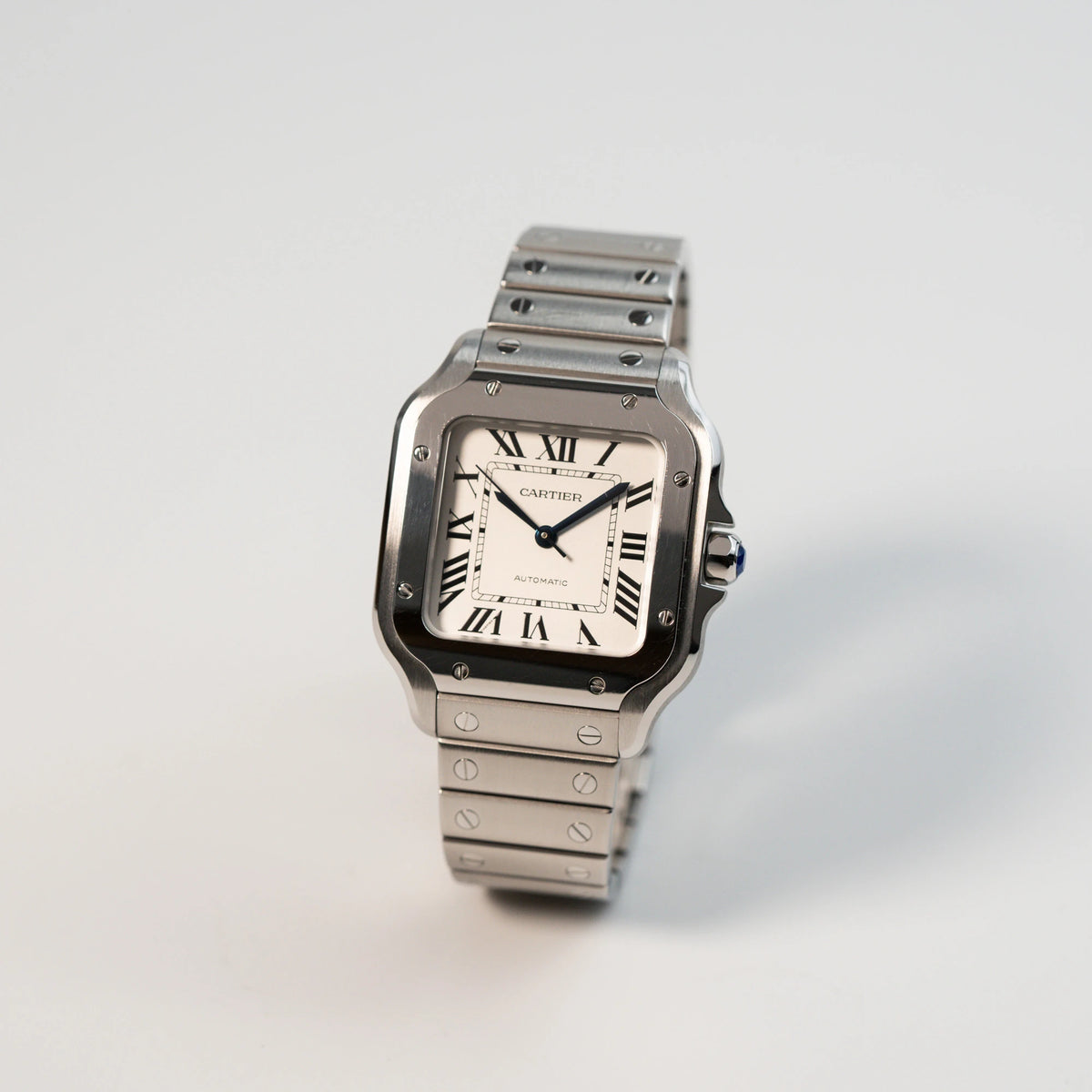 Leicht schräge Ansicht der Cartier Santos Medium mit dem klassischen weißen Zifferblatt mit römischen Indizes