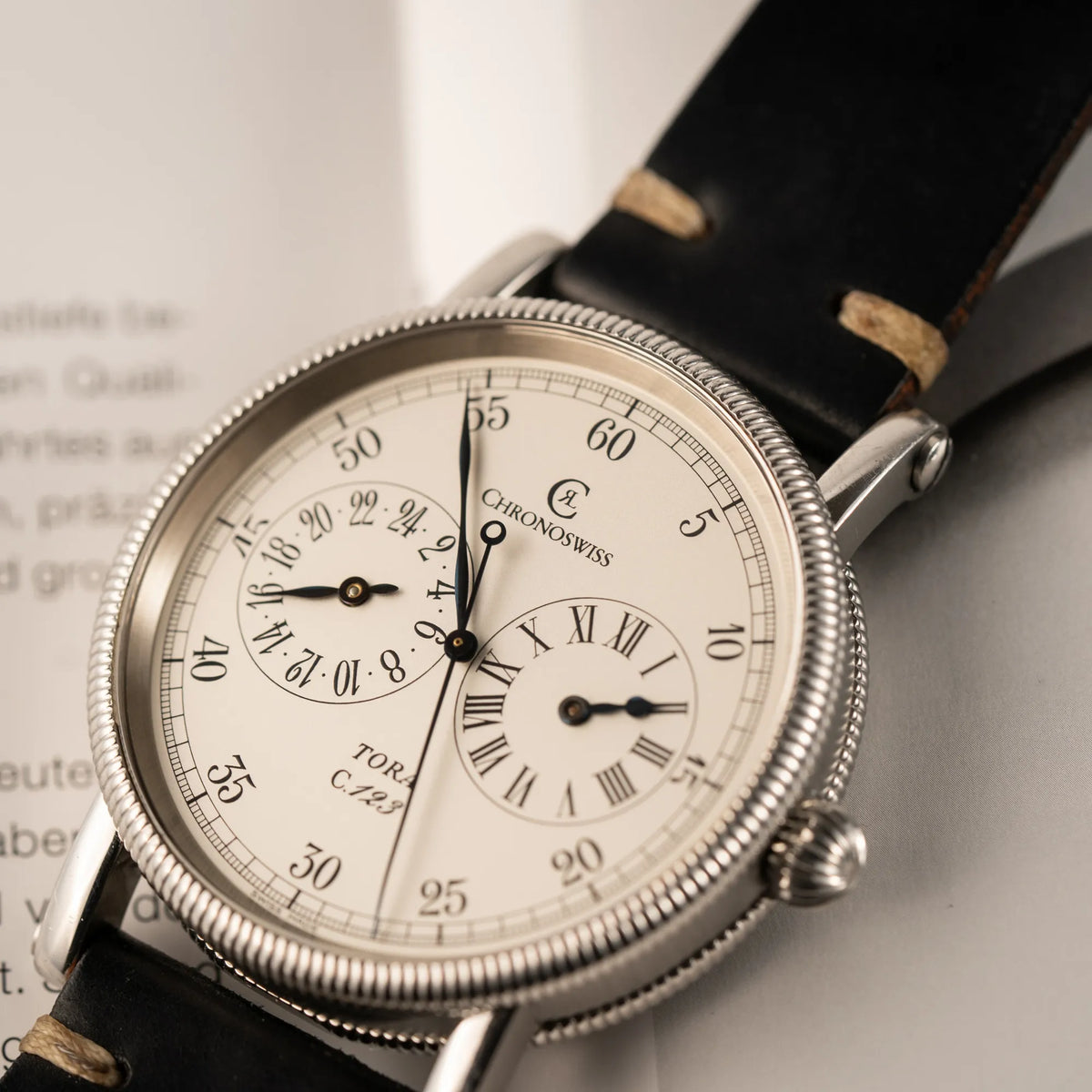 Produktfoto von der Chronoswiss Regulator Tora C123 mit weißem Zifferblatt mit zwei symmetrisch angeordneten Hilfszifferblättern mit römischen Indizes