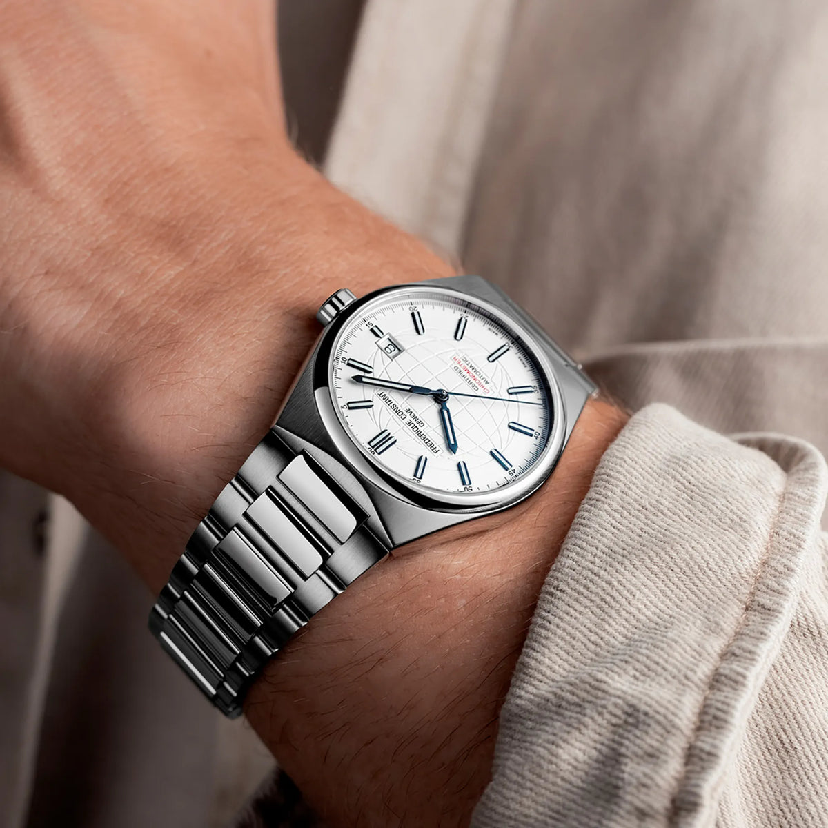 Mann trägt die "Highlife Automatic COSC" mit dem weißen Zifferblatt von Frederique Constant an seinem Handgelenk