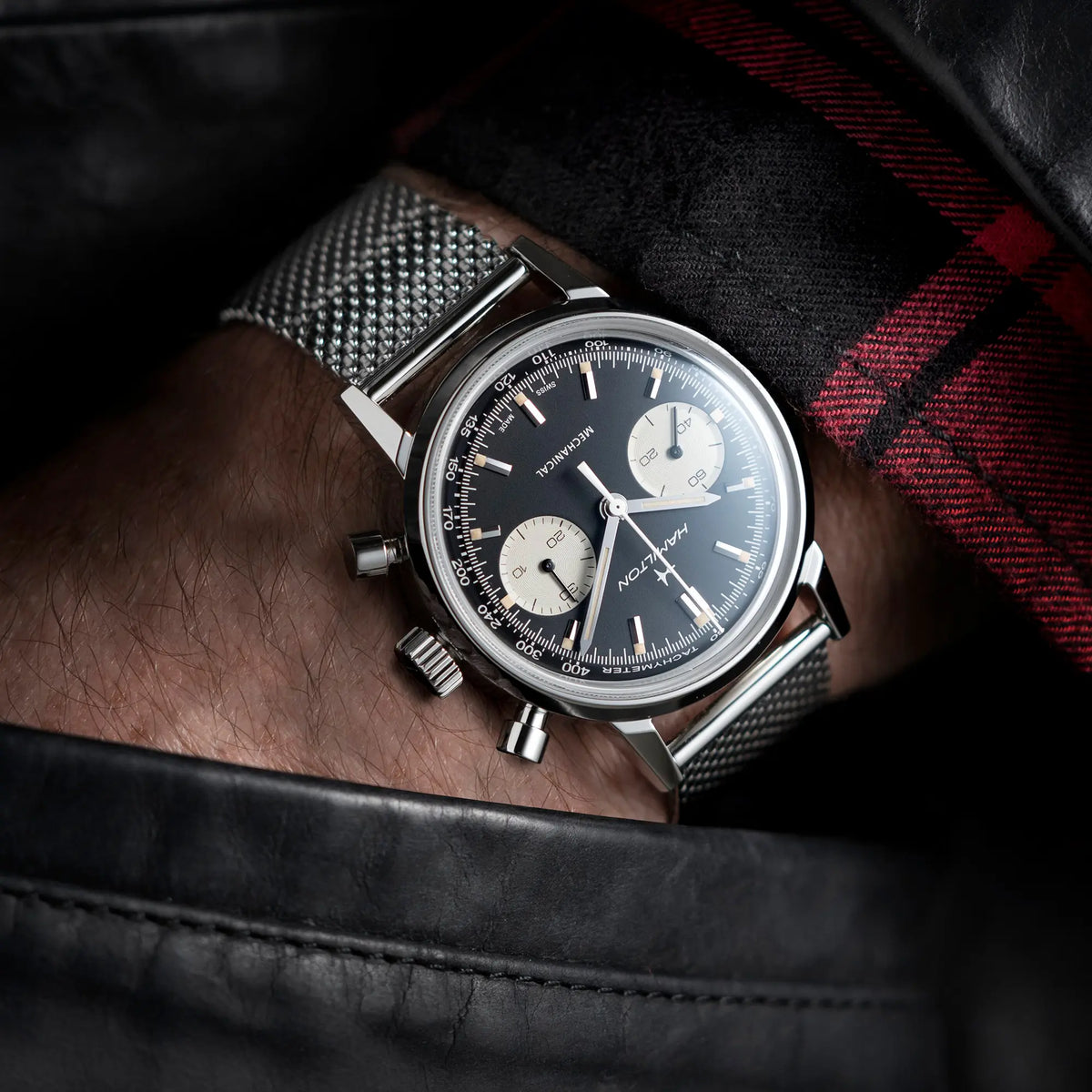 Mann trägt die Hamilton American Classic Intra-Matic Auto Chrono H38429130 mit dem Reverse-Panda Zifferblatt an seinem Hangelenk