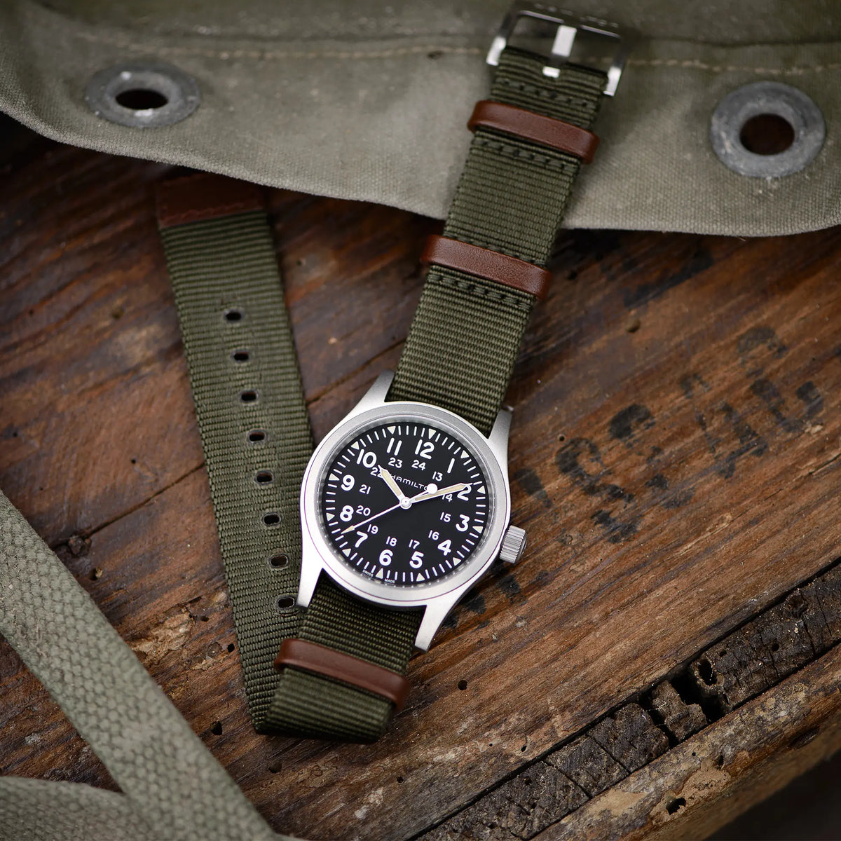 Lifestylebild der Hamilton Khaki Field Mechanical H69439931 mit weißem Zifferblatt an einem olivgrünem Nato-Textil-Armband