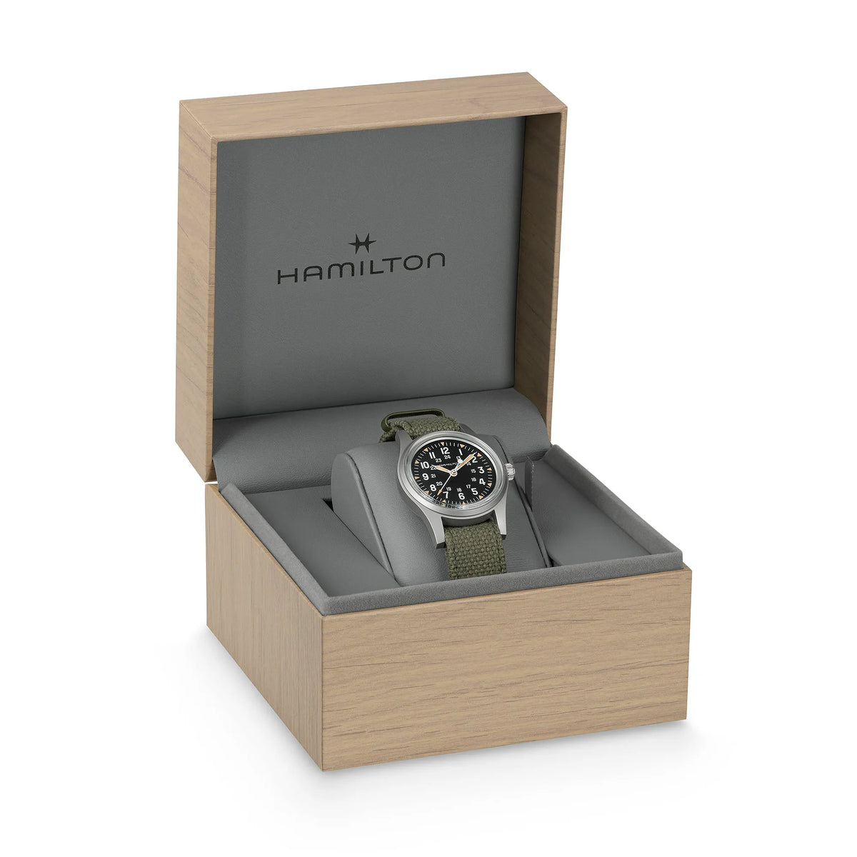 Hamilton Khaki Field Mechanical H69399930 mit schwarzem Zifferblatt im Vintage-Charakter mit Indizes in weiß und beige an einem khaki-farbenem Nato-Band zusammen mit der Uhrenbox in Holz-Optik