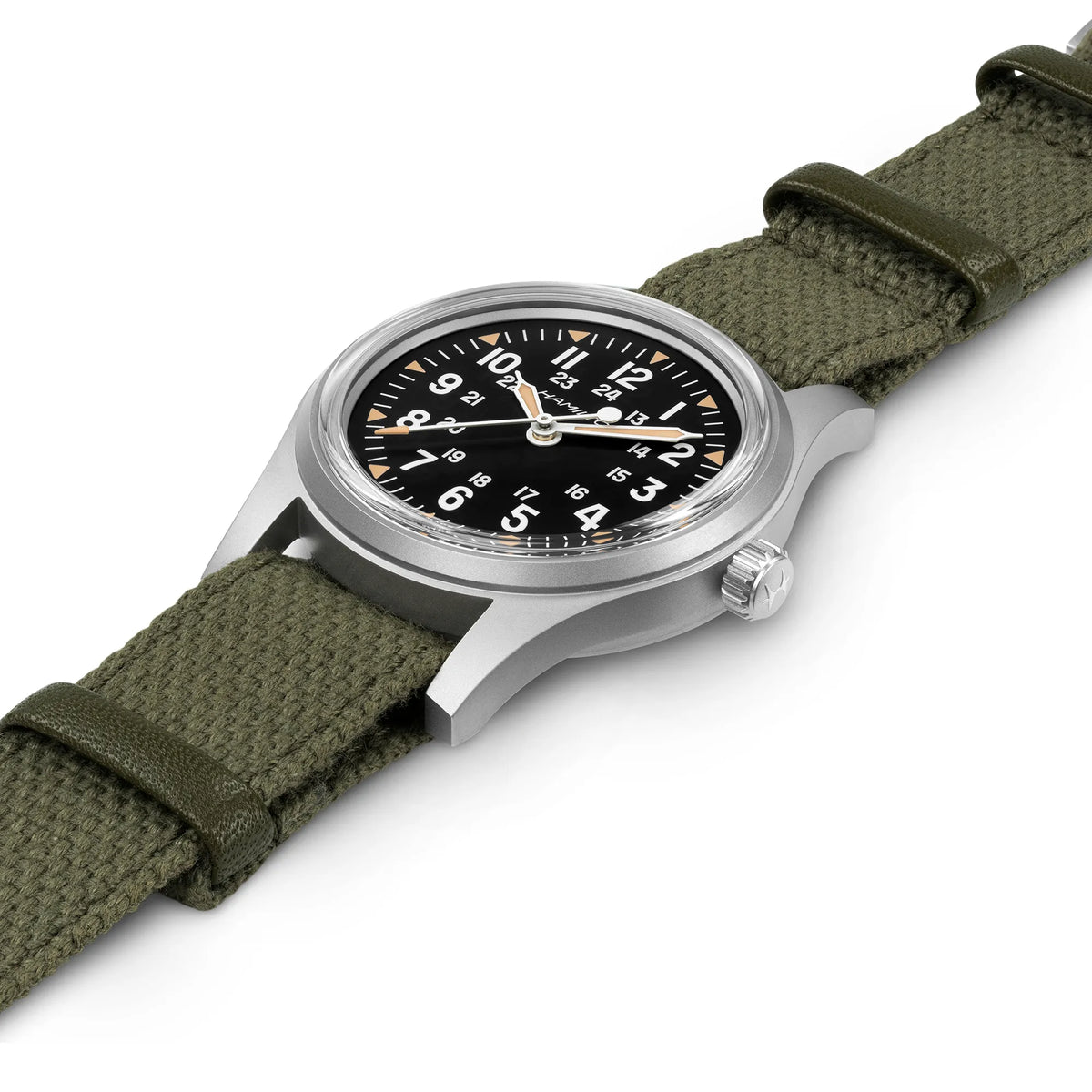 Leicht schräge Ansicht der liegenden Hamilton Khaki Field Mechanical H69399930 mit schwarzem Zifferblatt im Vintage-Charakter mit Indizes in weiß und beige an einem khaki-farbenem Nato-Band