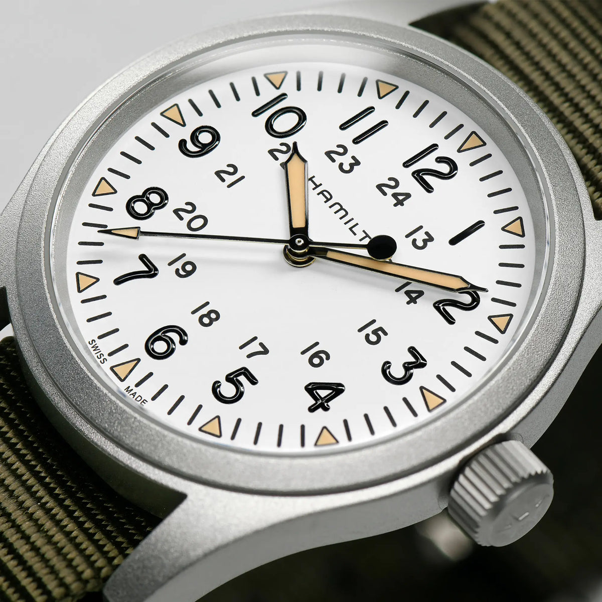Detailaufnahme der Hamilton Khaki Field Mechanical H69439411 mit weißem Zifferblatt am olivgrünen Nato-Armband