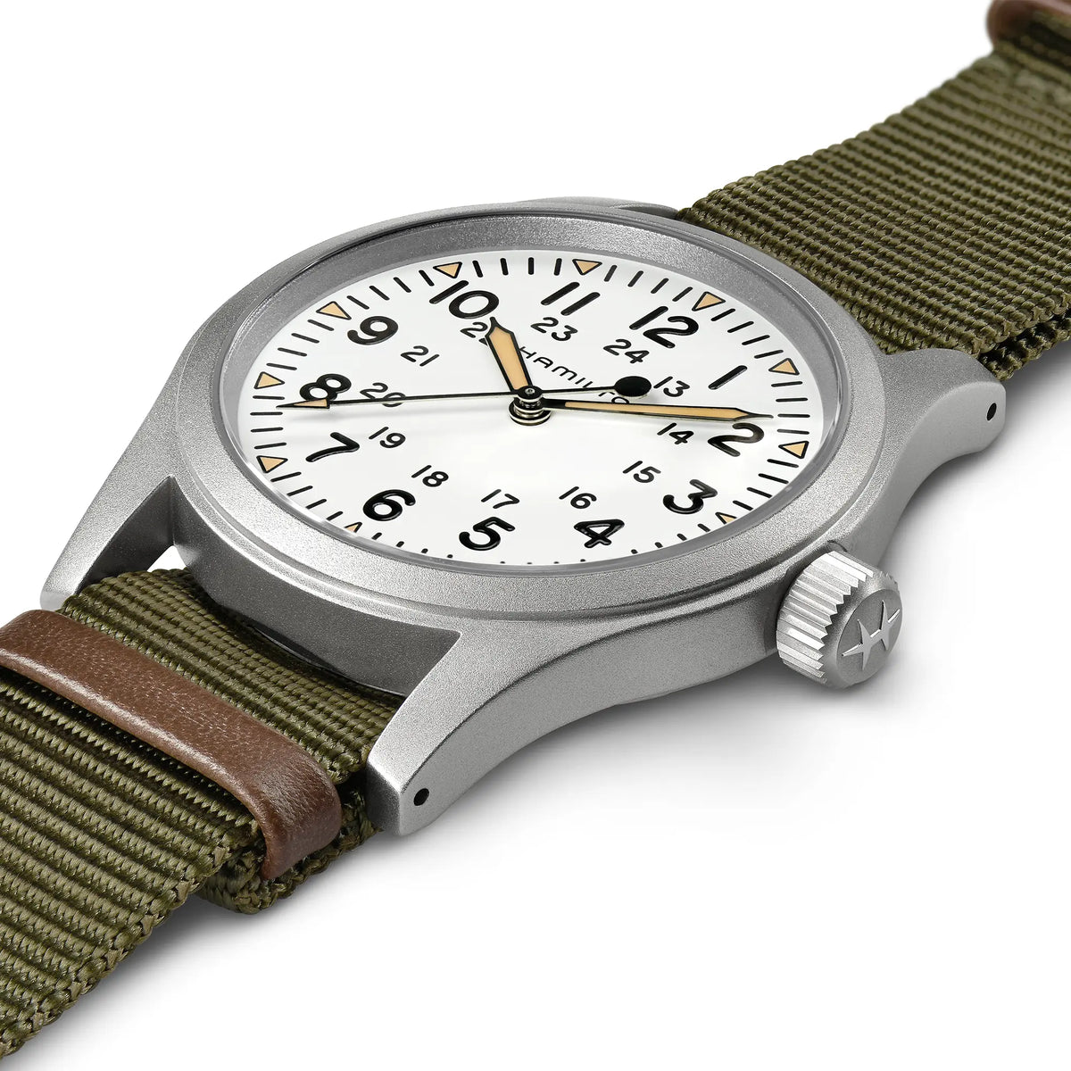 Leicht schräge Ansicht der Hamilton Khaki Field Mechanical H69439411 mit weißem Zifferblatt am olivgrünen Nato-Armband