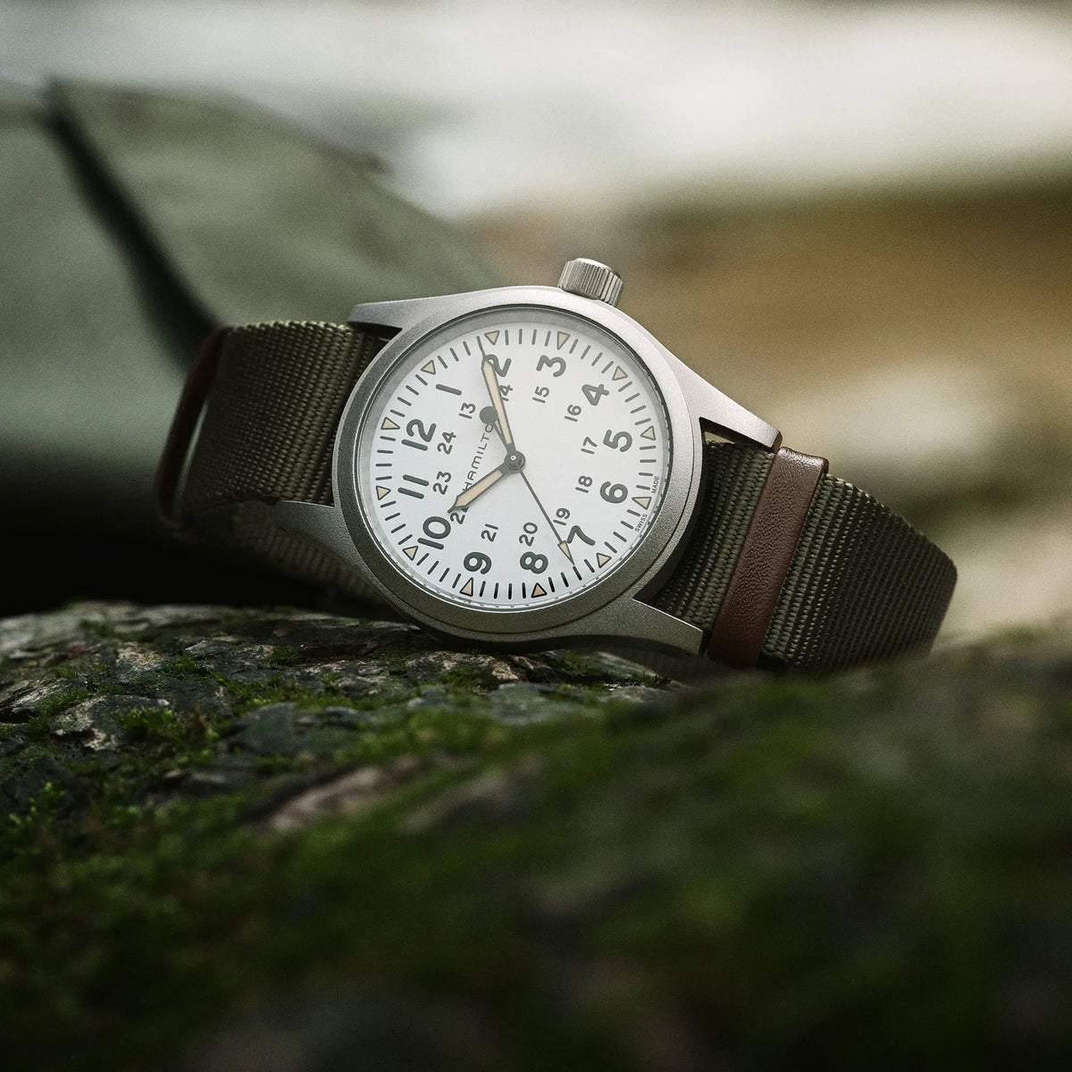 Produktfotografie der Hamilton Khaki Field Mechanical H69439411 mit weißem Zifferblatt am olivgrünen Nato-Armband