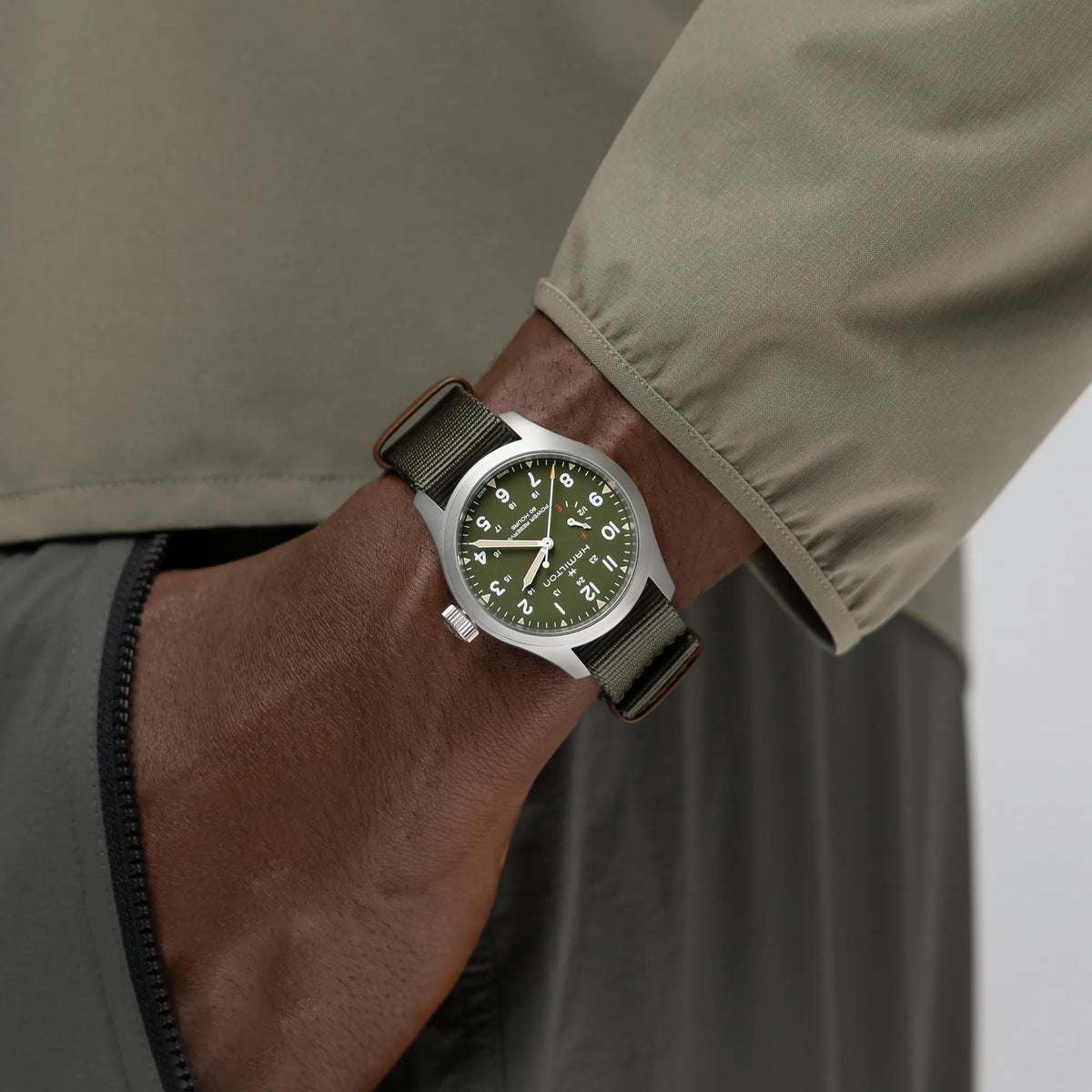 Wristshot mit der Hamilton Khaki Field Powerreserve H69509960 mit olivgrünem Zifferblatt am Hamilton-typischen olivgrünen Nato-Armband