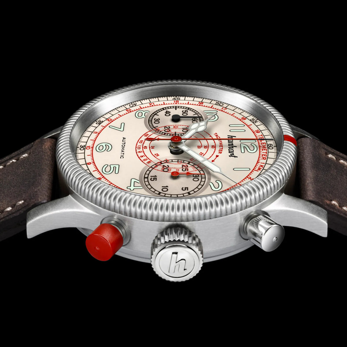 Seitliche Ansicht der Hanhart Pioneer TachyTele Chronograph mit altweißem Zifferblatt und rot gehaltener Tachymeter-Skala und Telemeter-Skala am braunen Kalbslederband mit Niete zeigt den charakteristischen roten Drücker