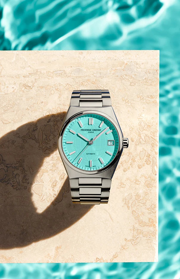 Produktfotografie der Highlife Ladies mit dem türkisen Zifferblatt von Frederique Constant über einem türkis-schimmerden Pool