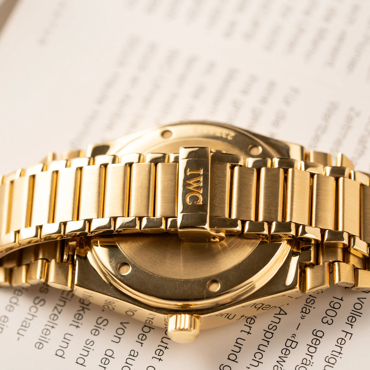 Detailaufnahme des Gehäusebodens und der Schliesse der IWC Ingenieur Perpetual Calendar in Gelbgold mit weißem Zifferblatt und zughörigem Gelbgold-Armband