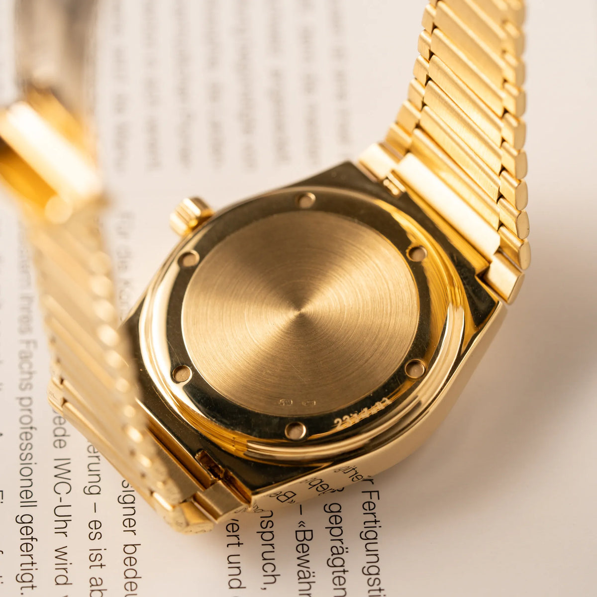 Gehäuseboden der IWC Ingenieur Perpetual Calendar in Gelbgold mit weißem Zifferblatt und zughörigem Gelbgold-Armband