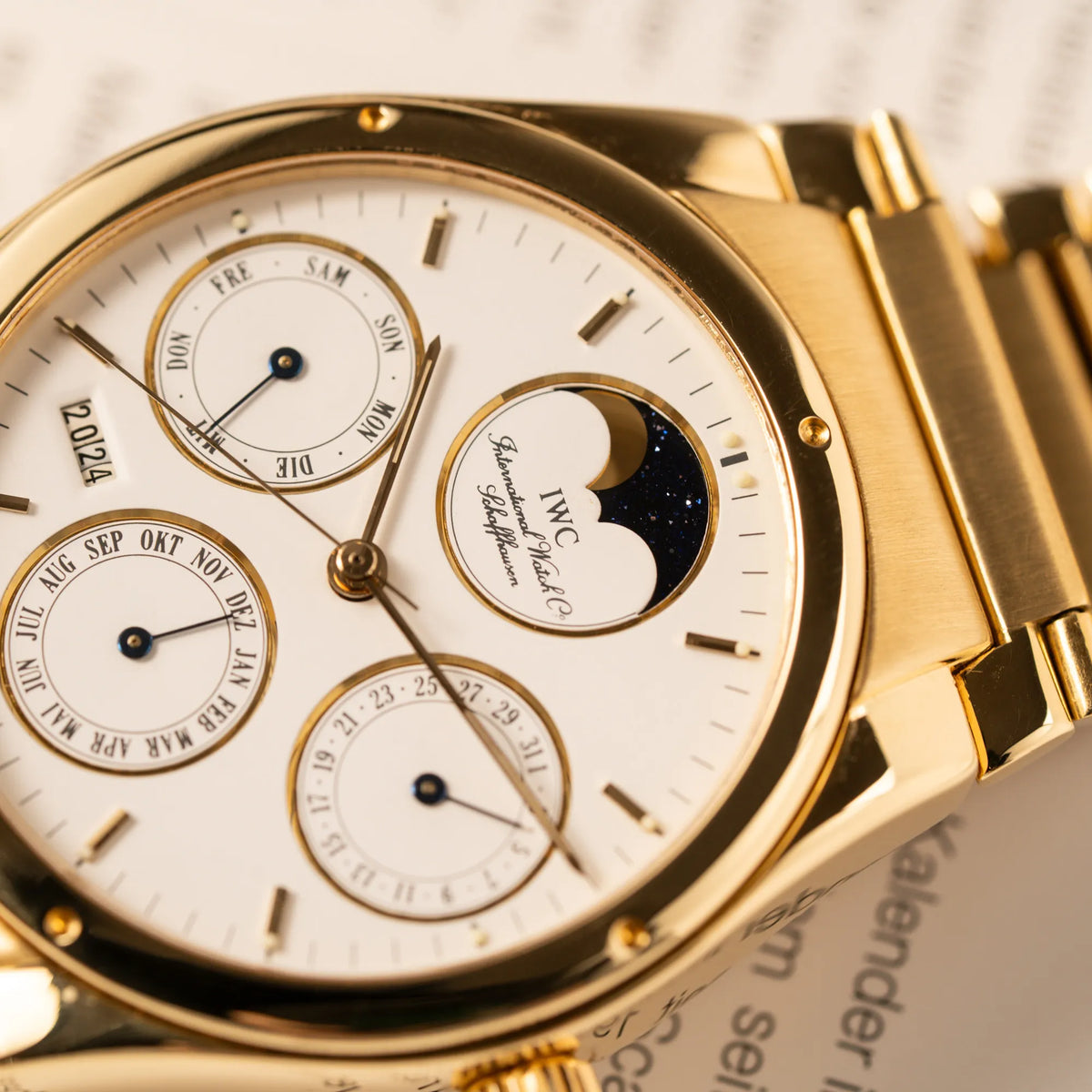 Detailaufnahme der IWC Ingenieur Perpetual Calendar in Gelbgold mit weißem Zifferblatt und zughörigem Gelbgold-Armband