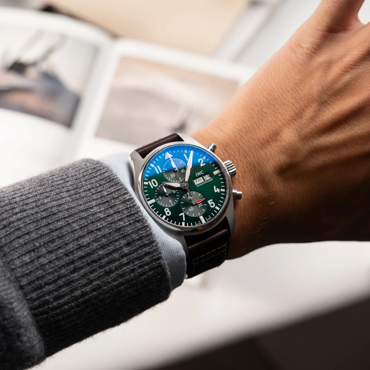 Mann trägt den IWC Pilot 41 Chronograph IW388103 mit grünem Zifferblatt an einem braunen Lederband an seinem Handgelenk