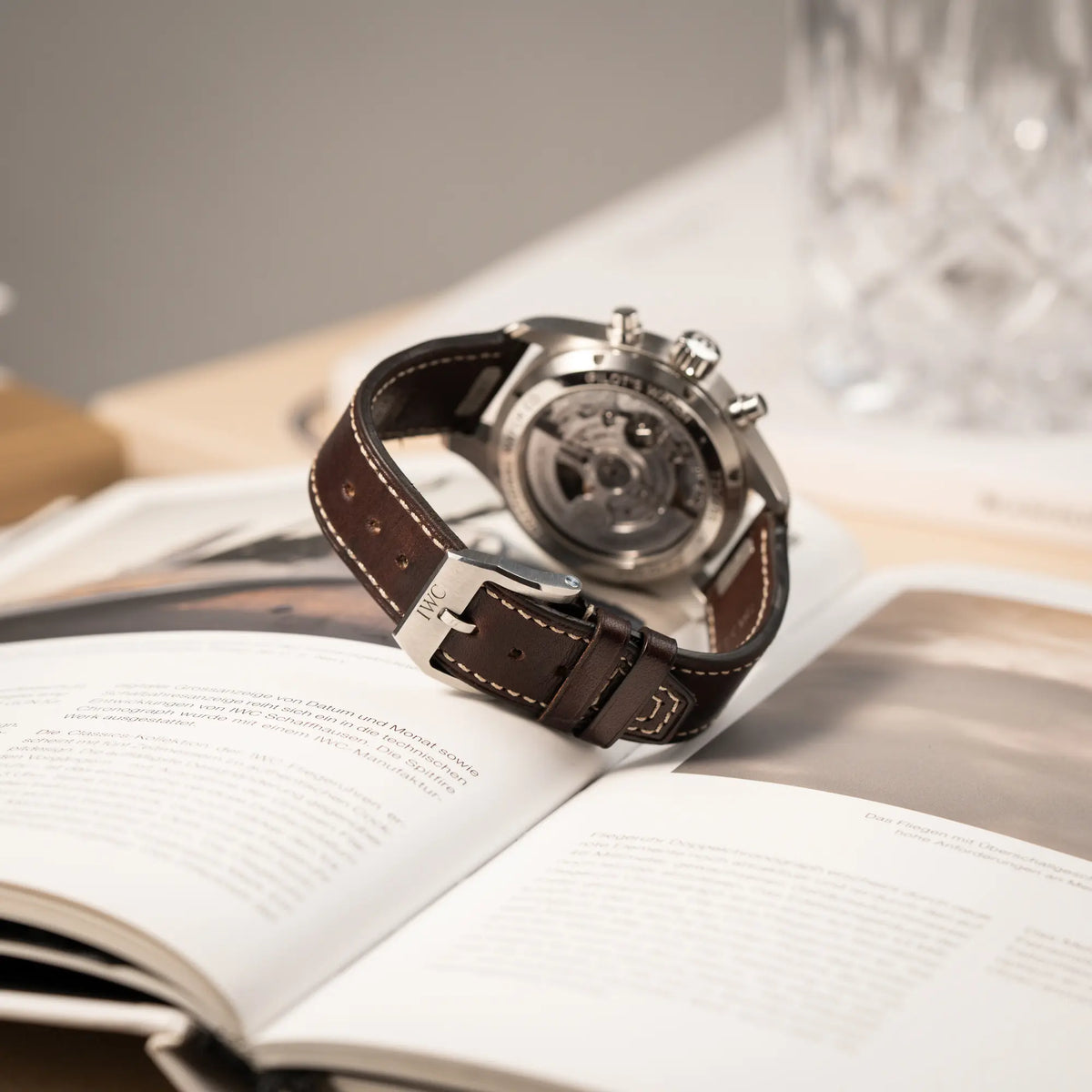 Produktfotografie des IWC Pilot 41 Chronographs IW388103 mit grünem Zifferblatt zeugt die originale geschlossene Dornschliesse an einem braunen Lederband