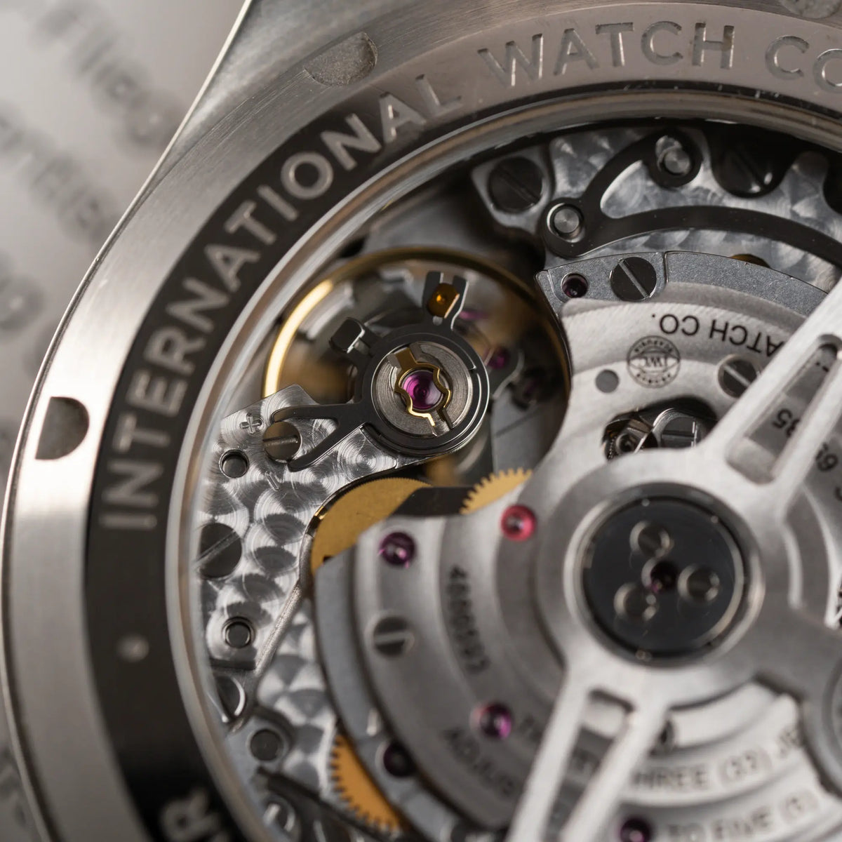 Uhruh des Calibers 69385 durch den Sichtboden des IWC Pilot 41 Chronographs IW388103 mit grünem Zifferblatt an einem braunen Lederband
