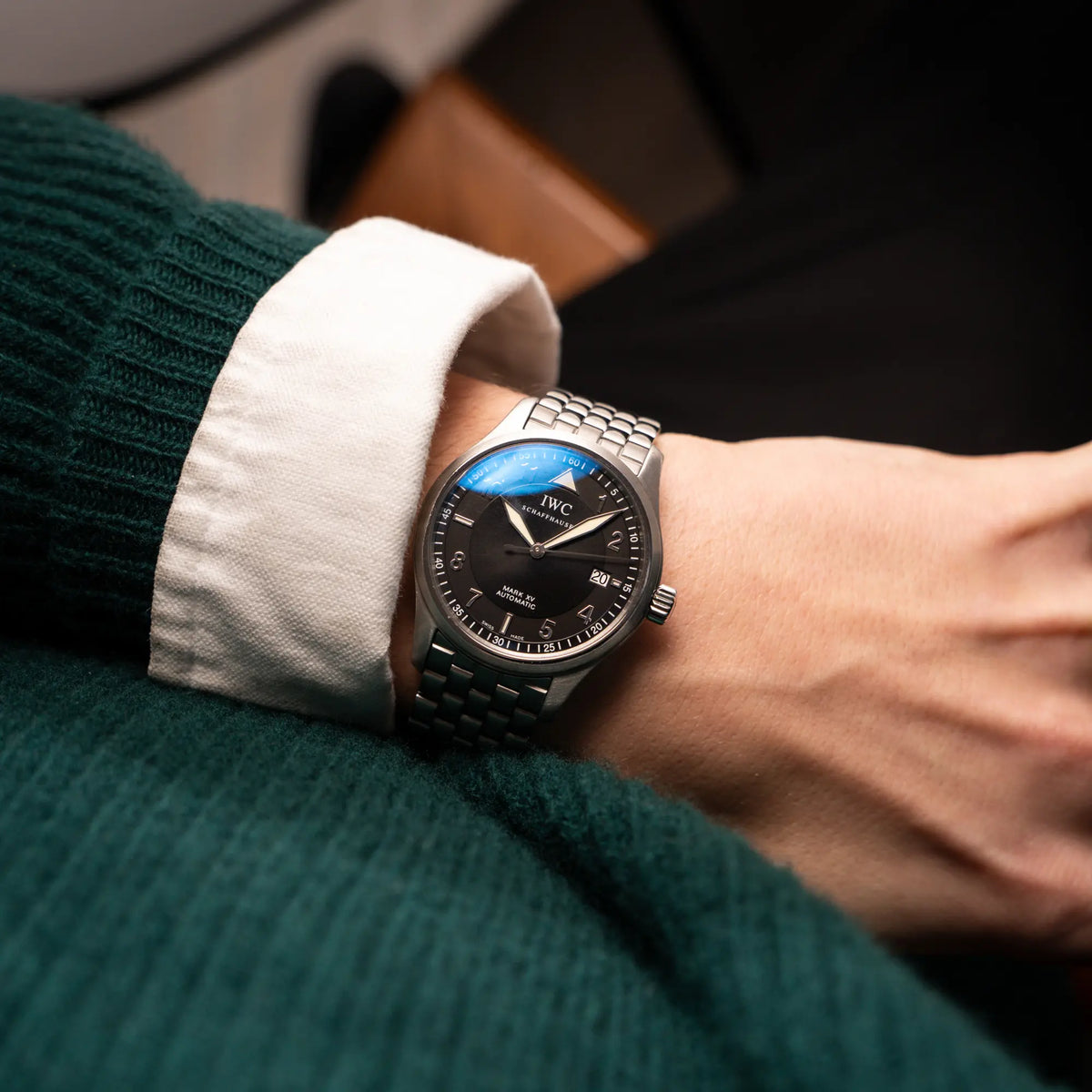 Mann trägt die IWC Pilot Fliegeruhr Mark 15 der Referenz IW325312 aus 2005 mit dem schwarzen Zifferblatt an dem passenden, originalen 5-gliedrigen Stahlband an seinem Handgelenk