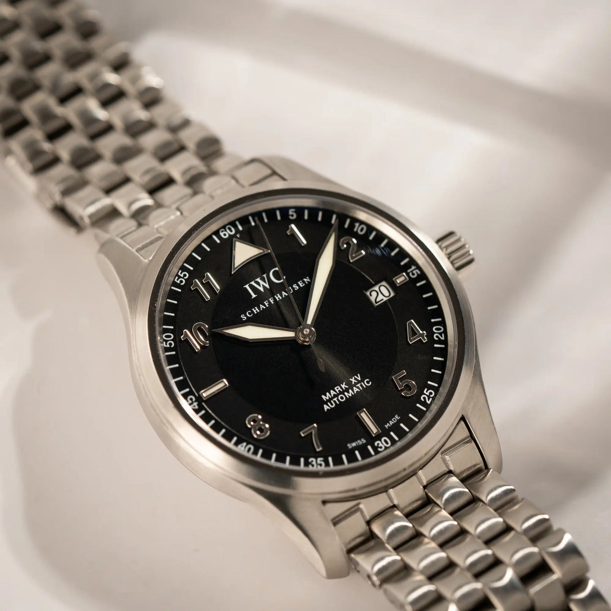 Detailaufnahme der IWC Pilot Fliegeruhr Mark 15 der Referenz IW325312 aus 2005 mit dem schwarzen Zifferblatt an dem passenden, originalen 5-gliedrigen Stahlband