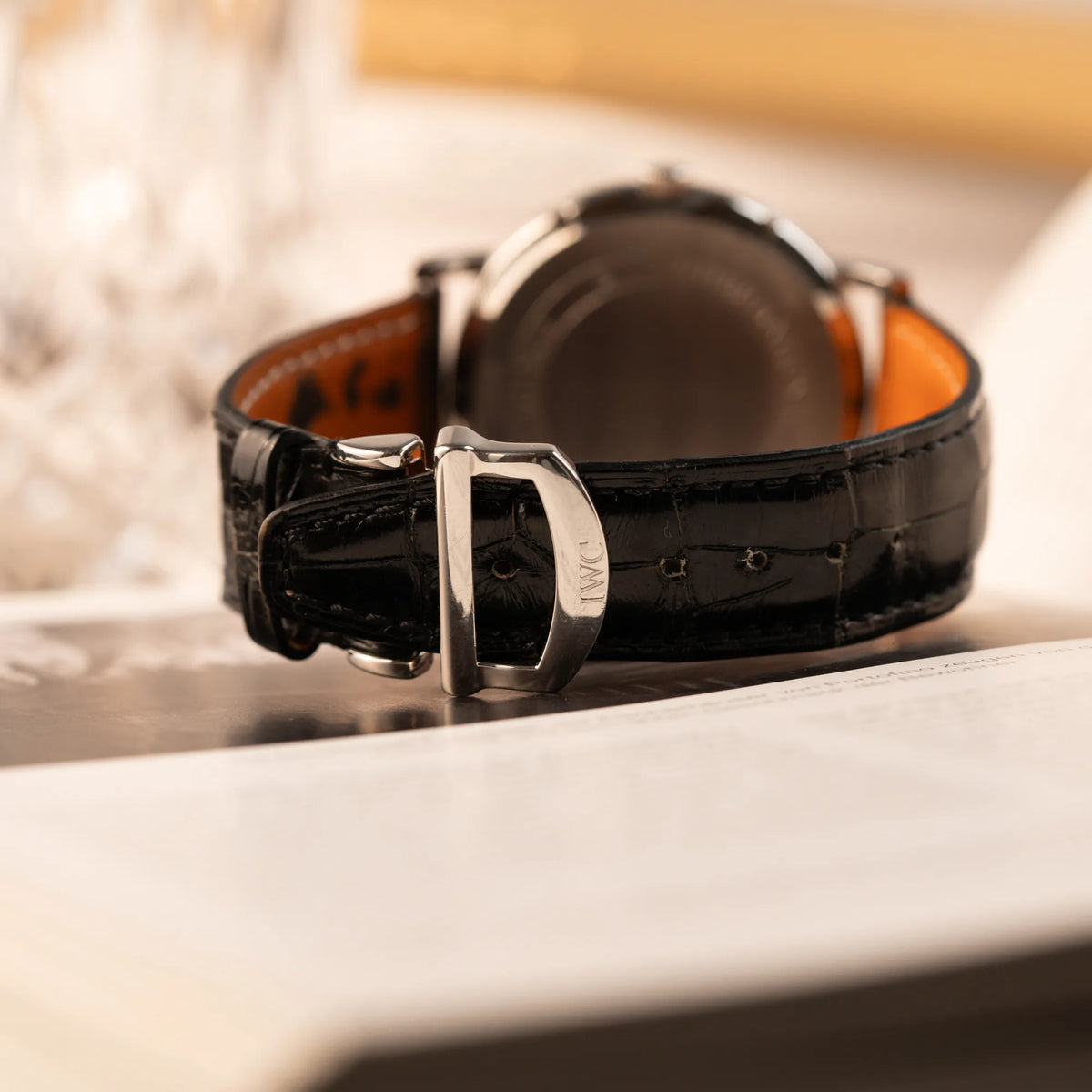 Produktfotografie zeigt das schwarze Lederband und die IWC Faltschliesse der IWC Portofino Automatik IW356305 Armbanduhr mit minimalistischen, schwarzem Zifferblatt mit Stichindizes 